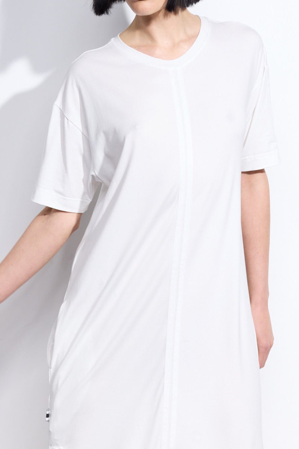 Close up of grosgrain ribbon stripe detail on front of a white dress with short sleeves on a person - ANNIE.G