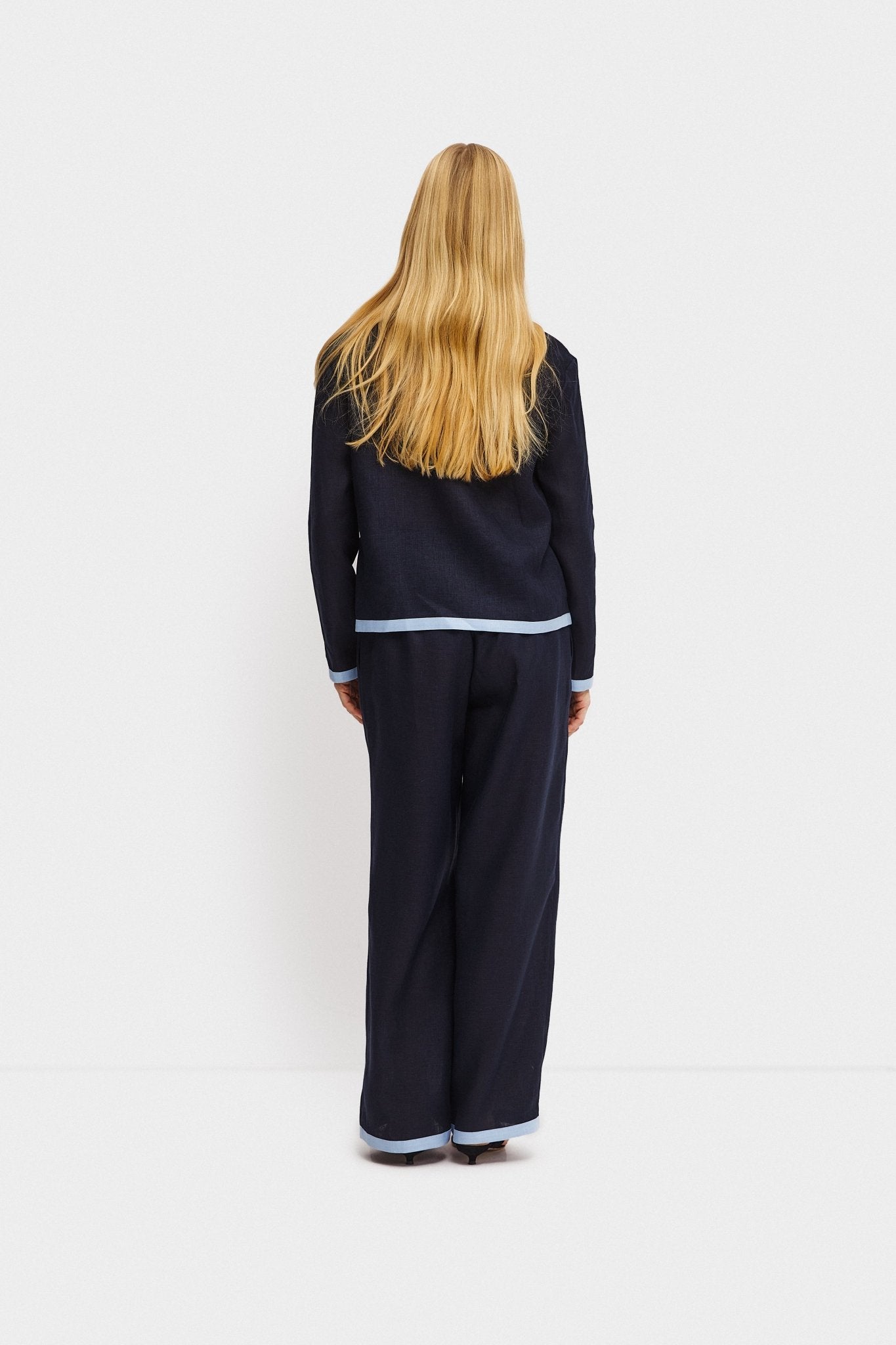 Back of a woman wearing a navy shirt with long sleeves and contrast blue trim at hem and cuff with matching long pants - ANNIE.G