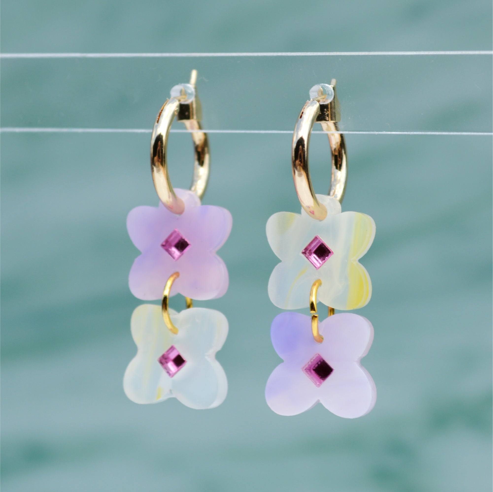 Two sweet clover acrylic flowers inset with gold mirror diamond in yellow and lavender swirl acrylic on small gold hoops.