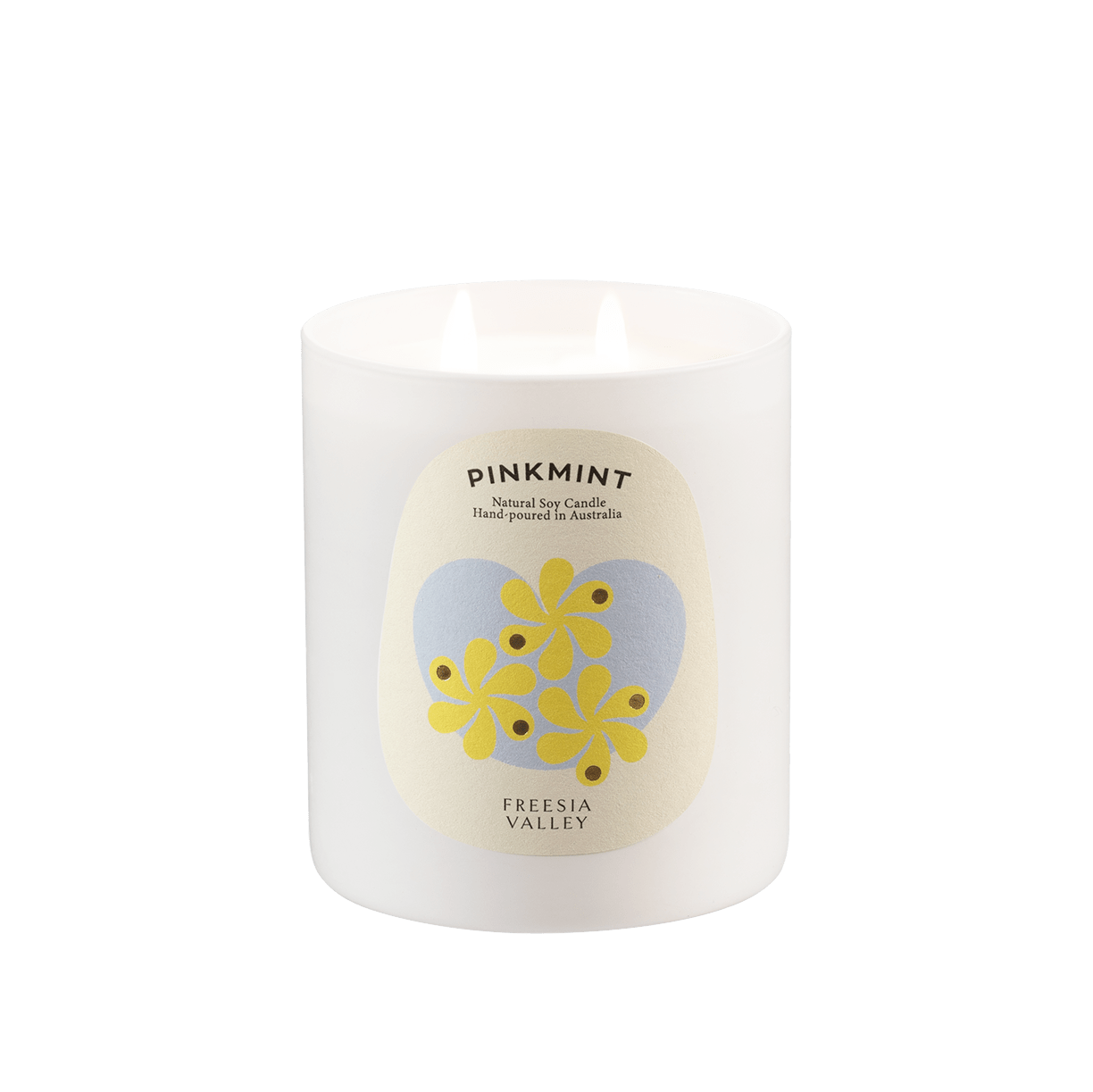 White glass jar with white soy wax candle lit inside and a floral label.