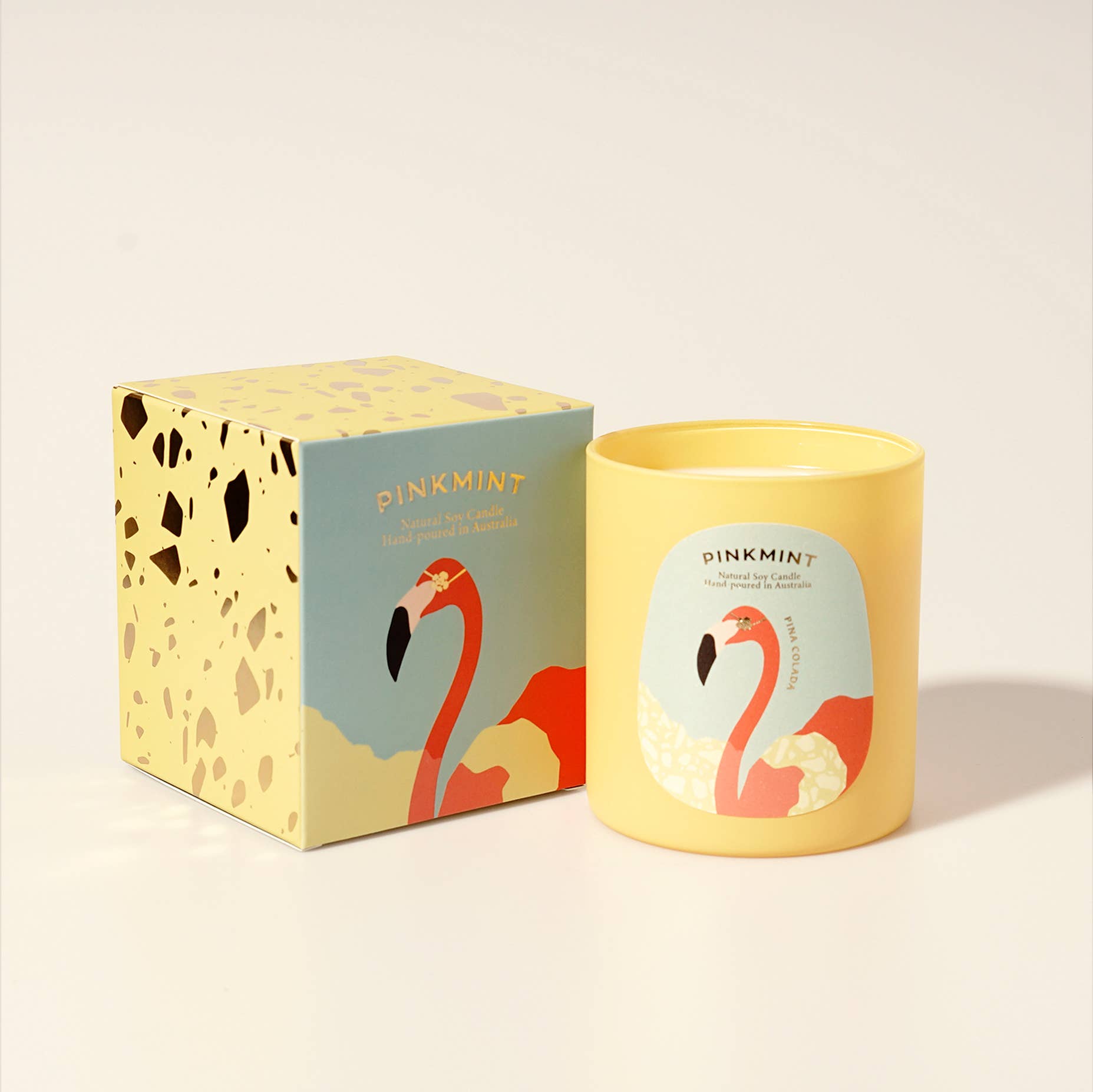 Candle box next to yellow jar candle with flamingo on label - ANNIE.G