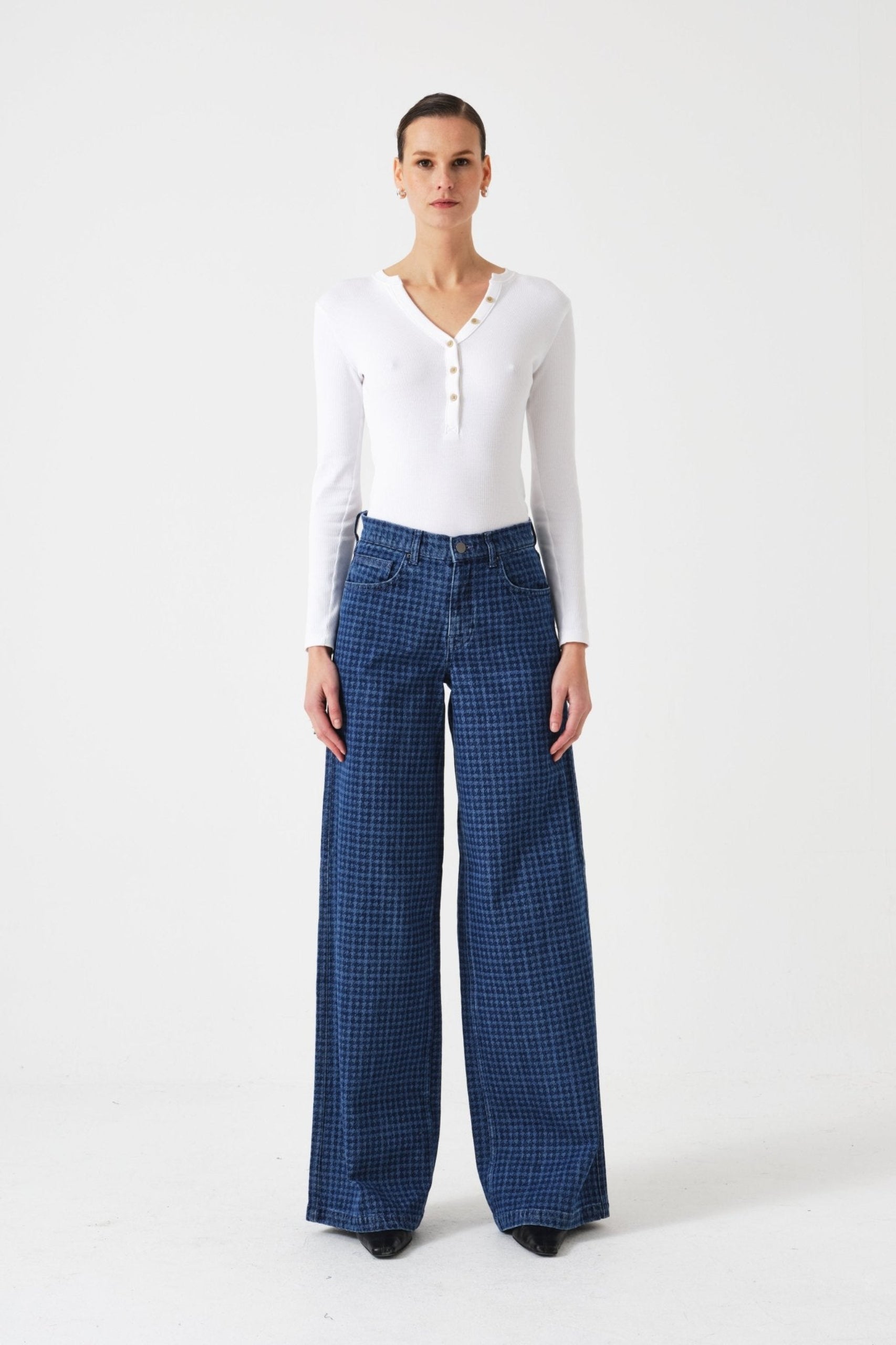 Woman wearing a white long-sleeve top and blue checkered pants