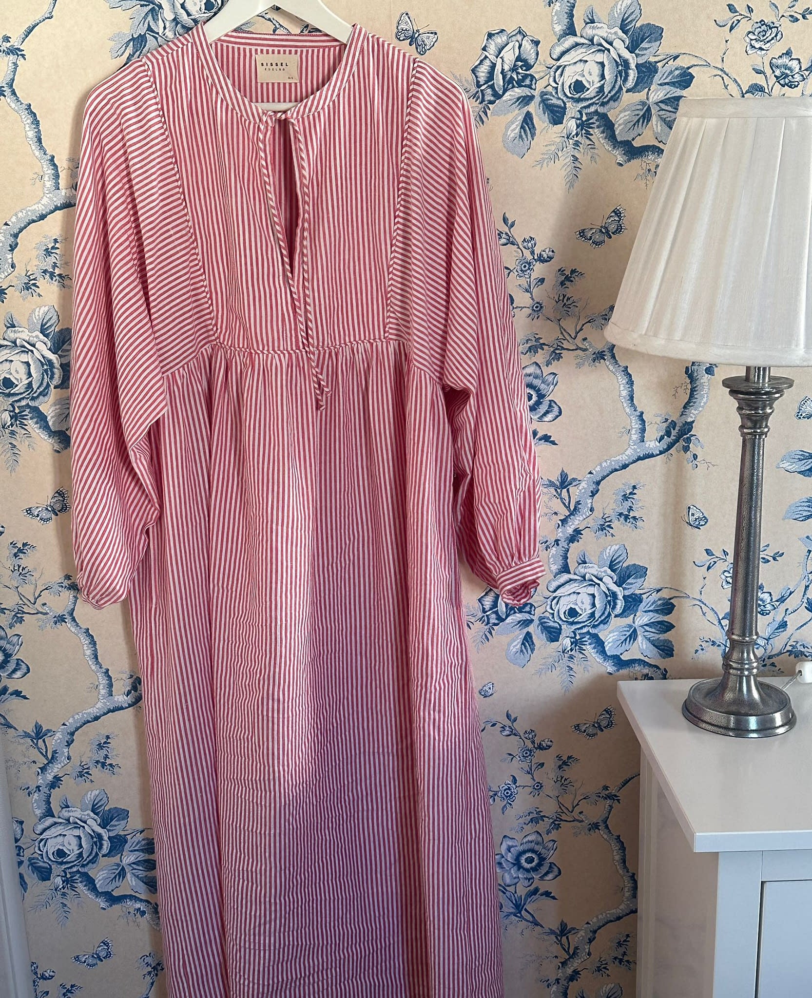 Red and White stripe dress hanging on wall near lamp - ANNIE.G