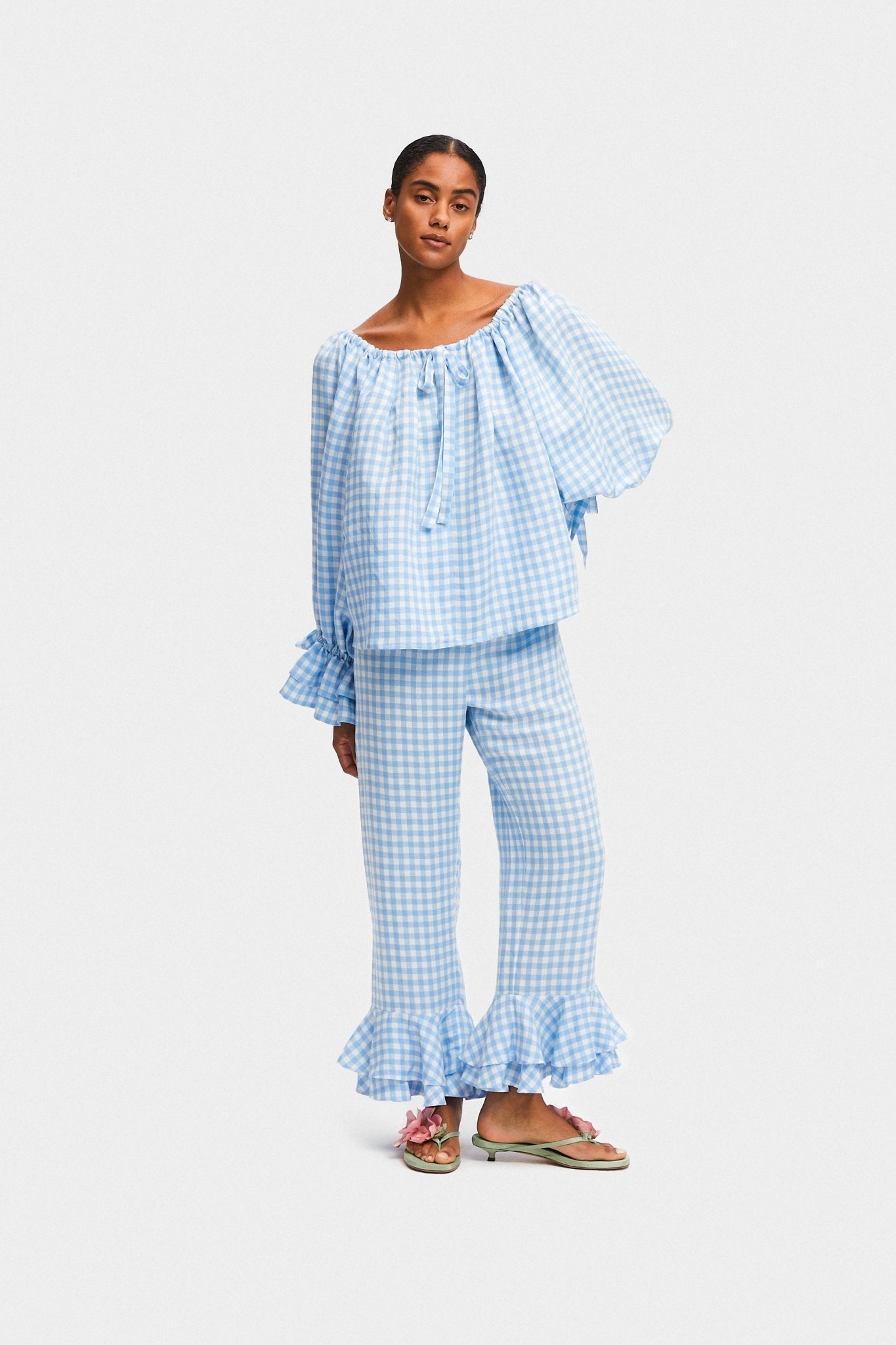 Woman wearing a blue gingham linen lounge shirt with drawstring cuff and neck and pants with frill - ANNIE.G