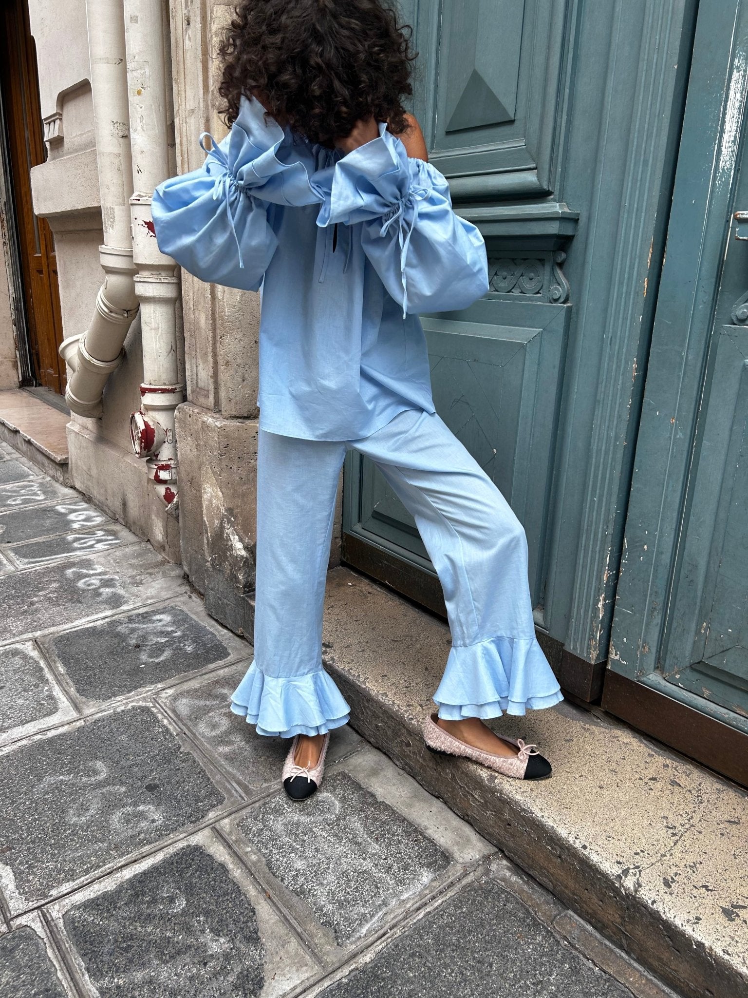 Person wearing a blue outfit set of shirt with long sleeves and tied cuff and pants with ruffles - ANNIE.G