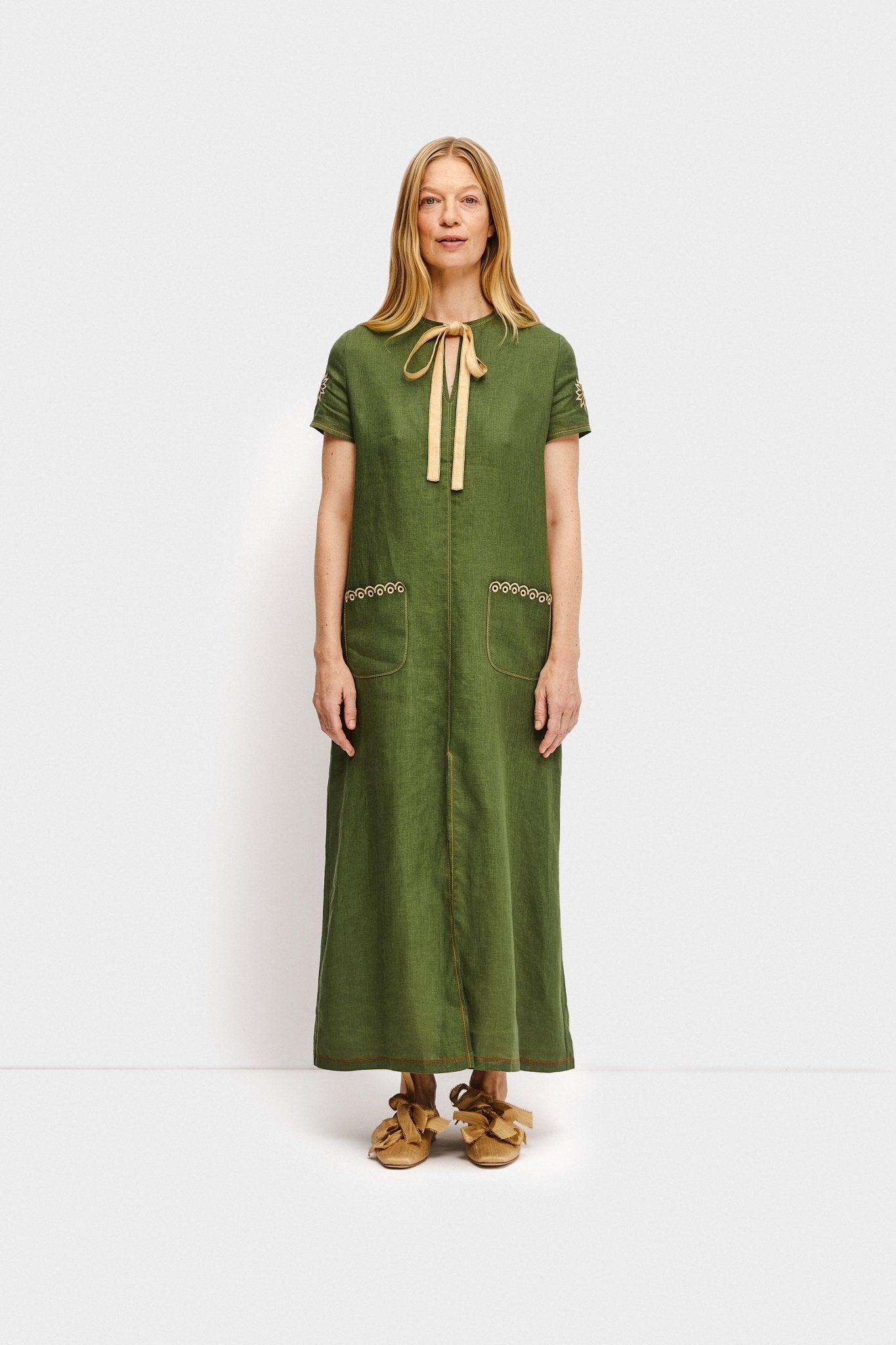 Woman wearing gold Mille - feuille Silk Flats with Bows and a green dress - ANNIE.G