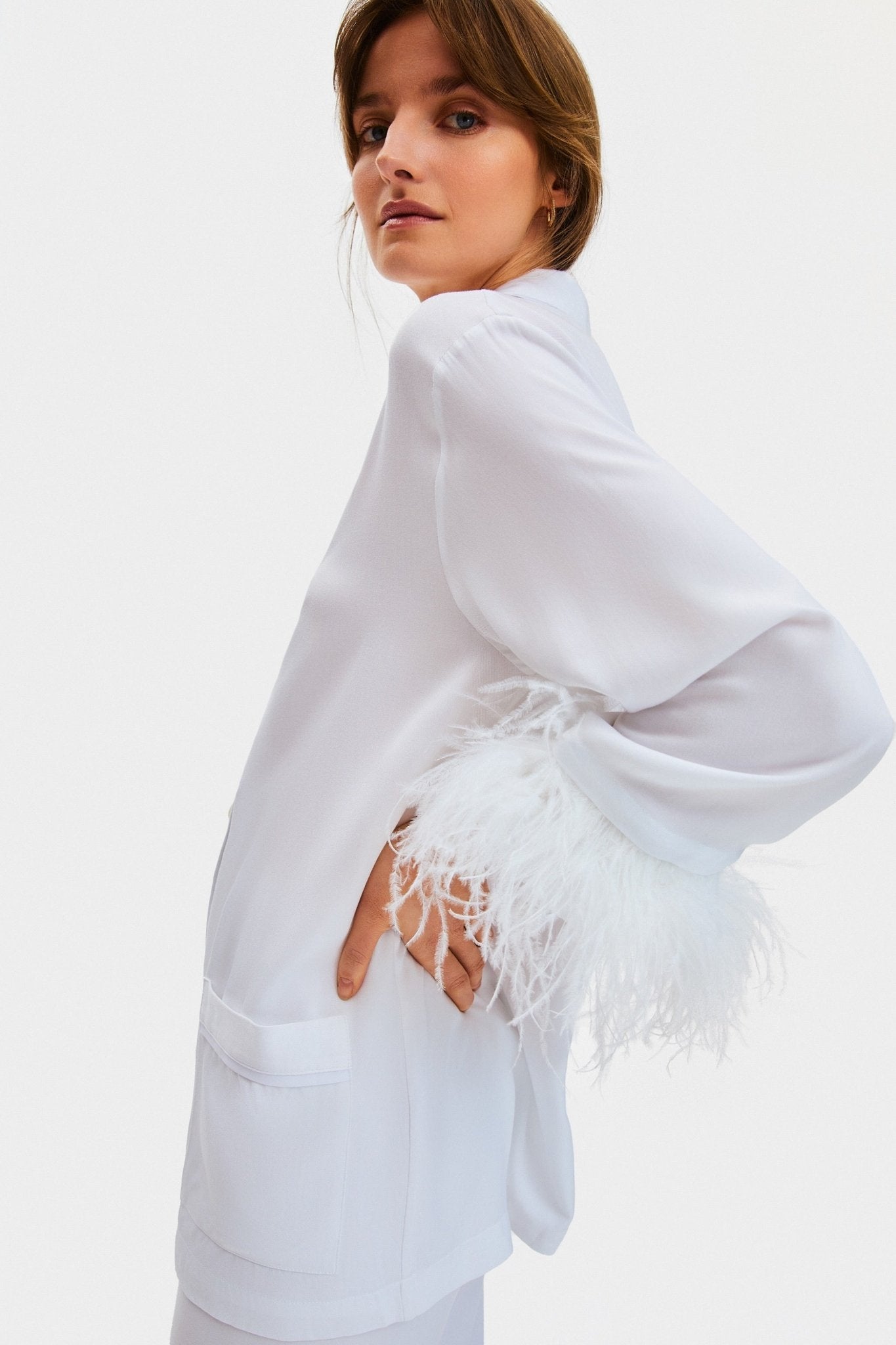 Woman standing on the side wearing white Party Pyjamas Set with Double Feathers and patch pockets.