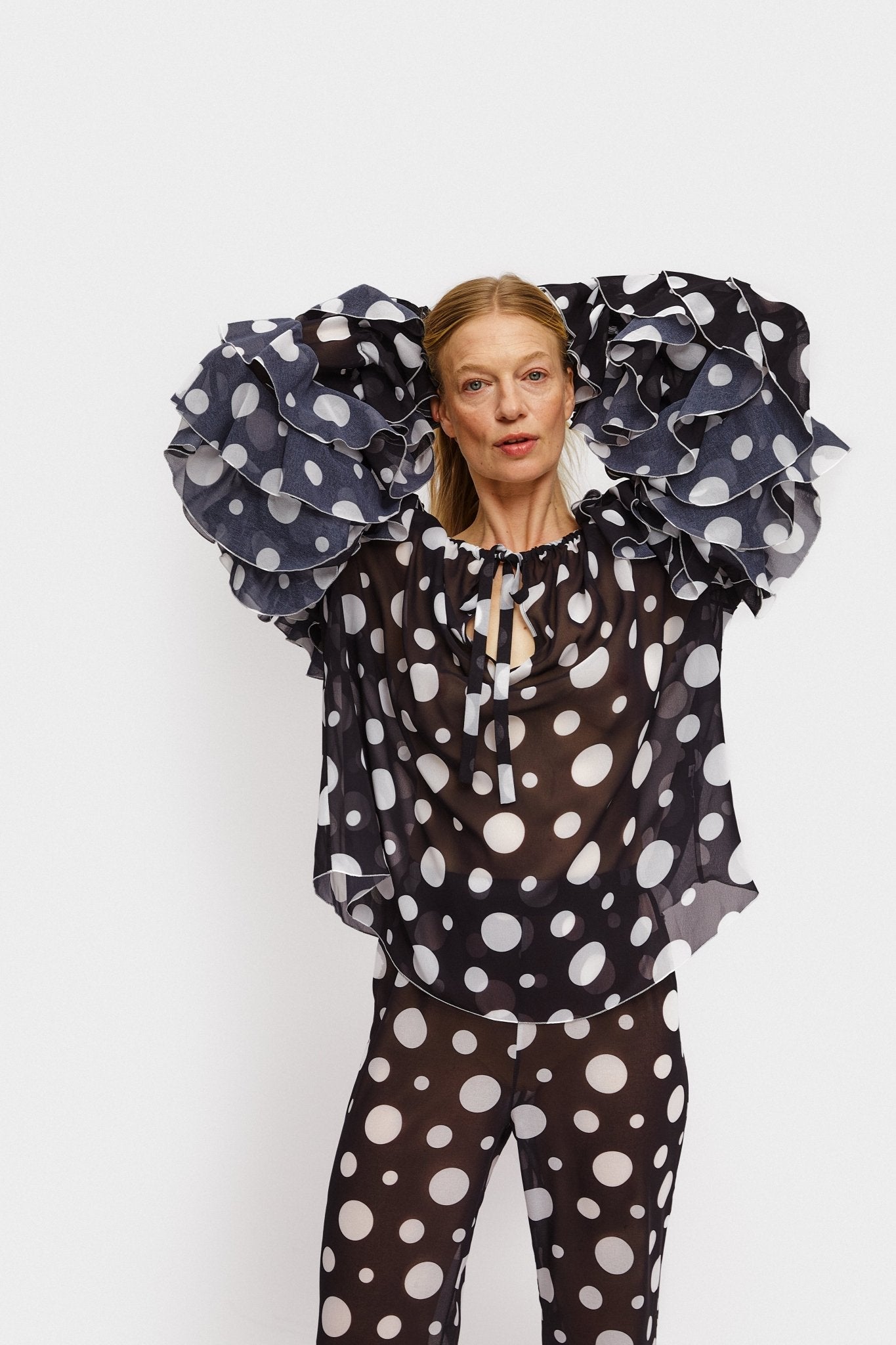 Sleeve detail on Samba Ruffled Chiffon Polka - dot top in Black on a woman.