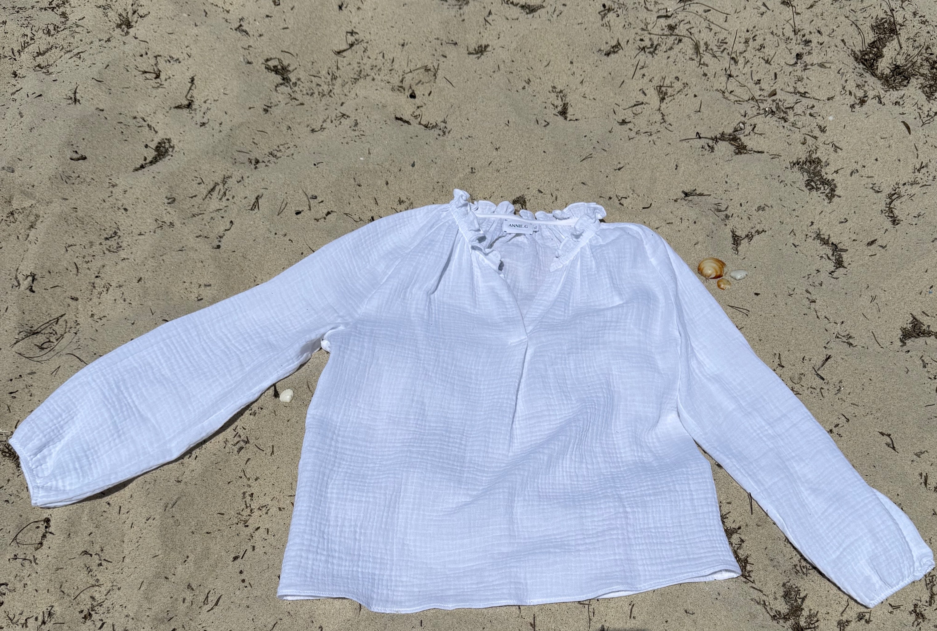 annie.g-annie-shirt-cloud_white-flat-lay-on-beach-front