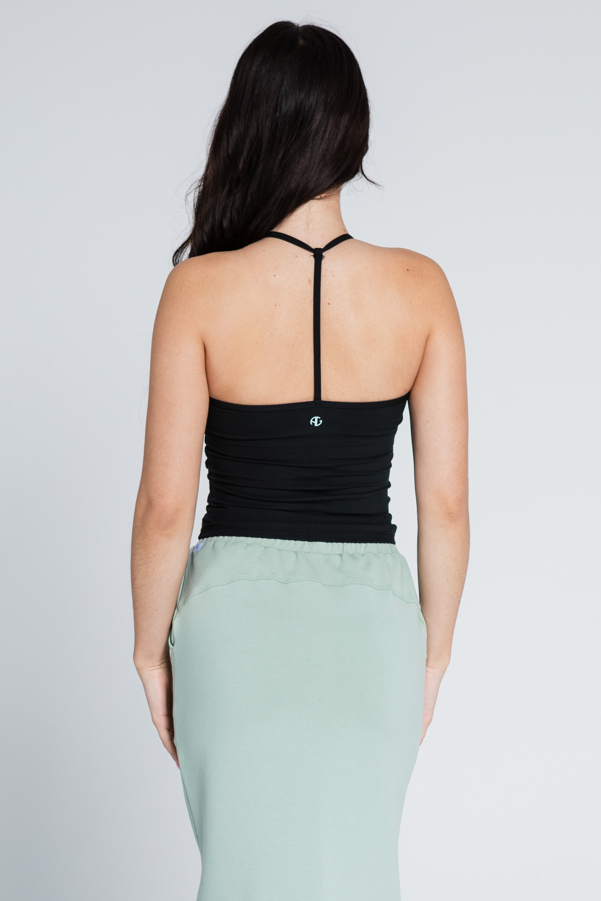 woman-wearing-black-t_strap-top-and-hampton_green-skirt-back-close-up