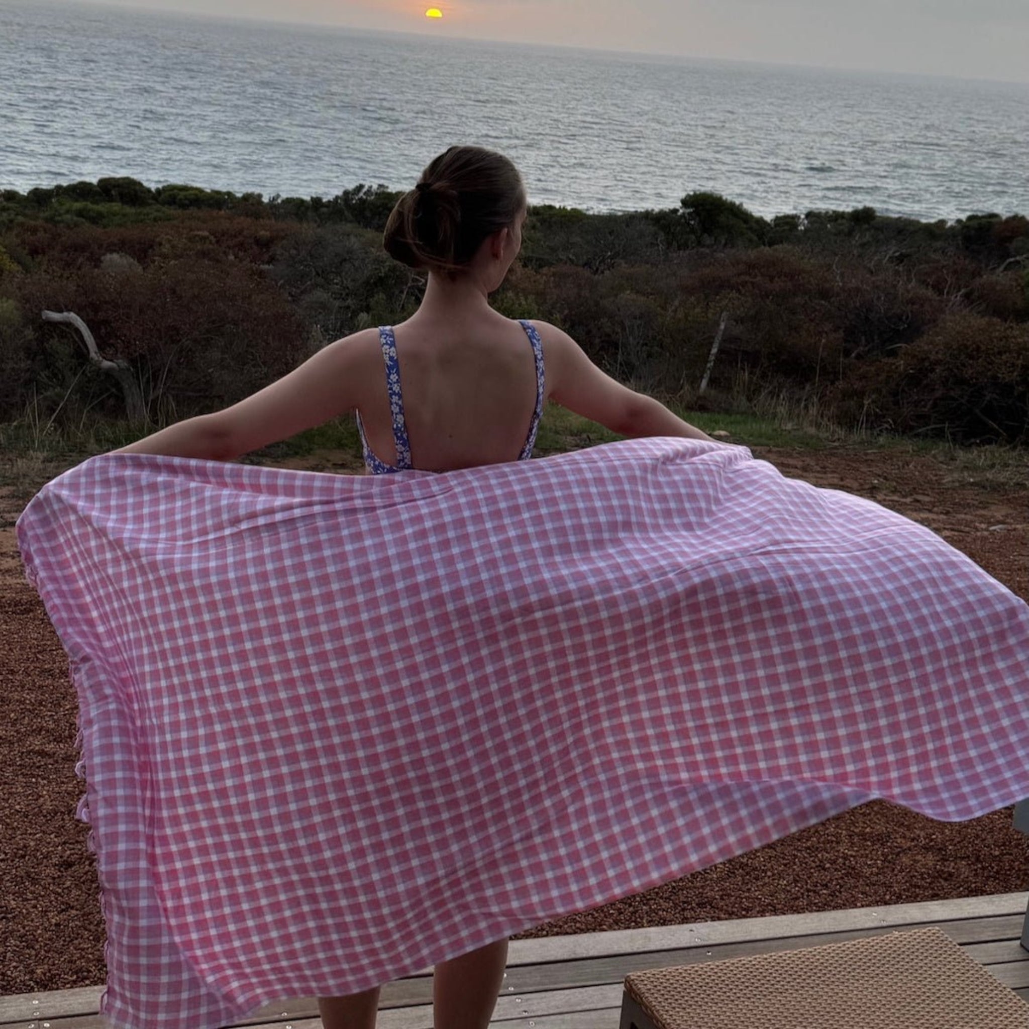 Woman wrapping the pink check beach towel around her body - ANNIE.G