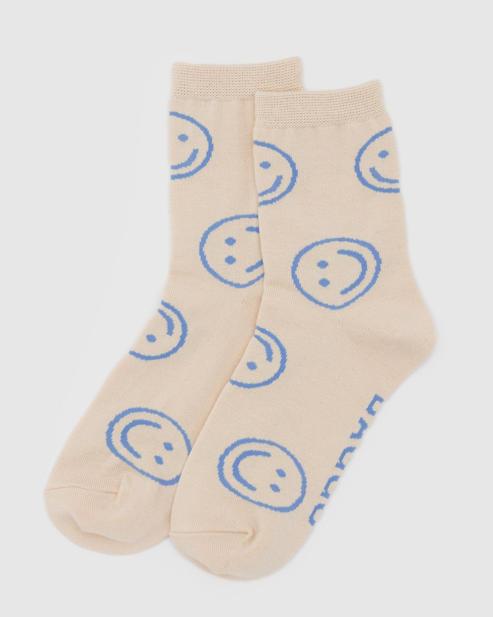 Ecru coloured crew socks with blue happy face pattern.