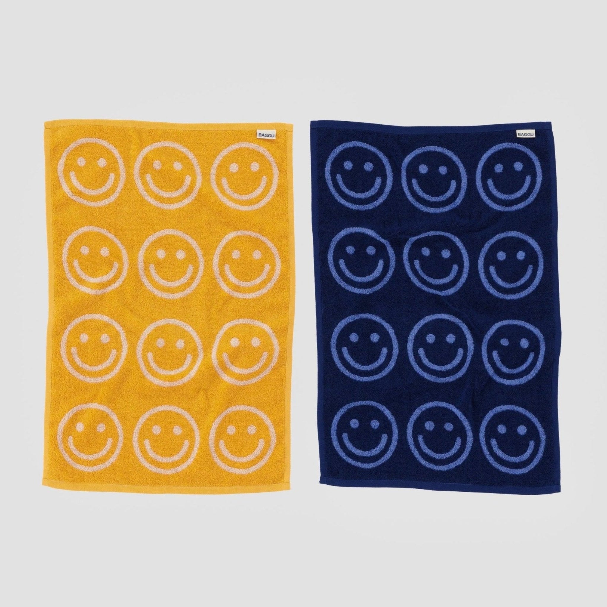 Back of a yellow and a blue Reversible Hand Towel Set of 2 with smiley face print.