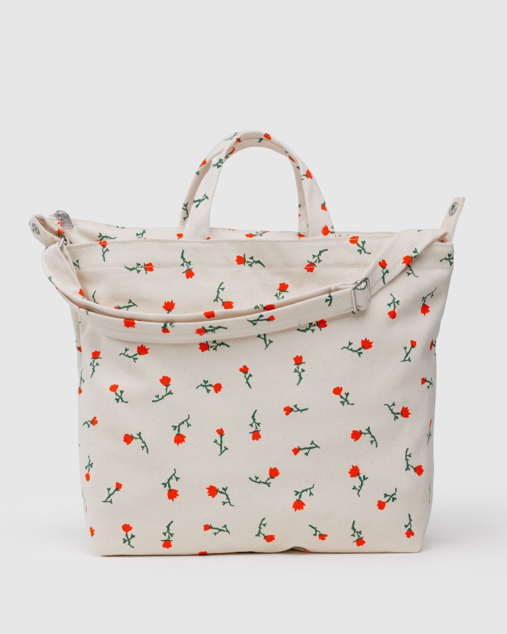 White with red wildflower patterned tote bag with carry handles, adjustable strap with silver hardware and zip top closure