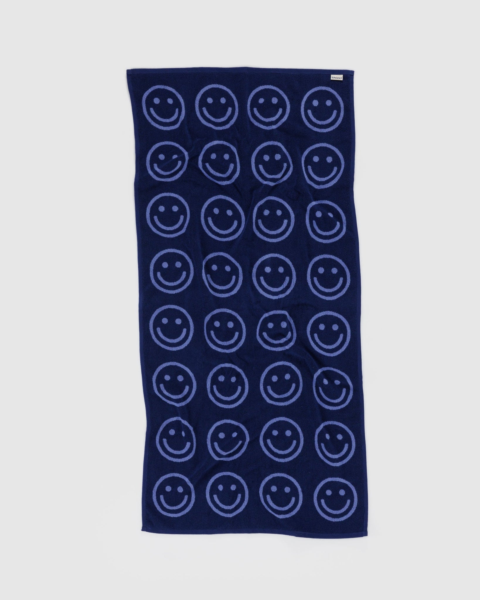 Back of navy blue towel with smiley face pattern.