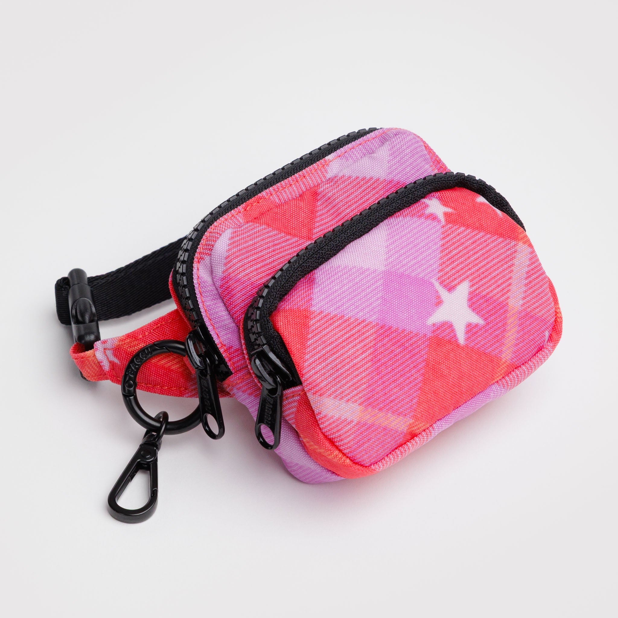 Pink and red geometric patterned pouch with adjustable logo black strap, two zip pockets and metal keyring with clip.