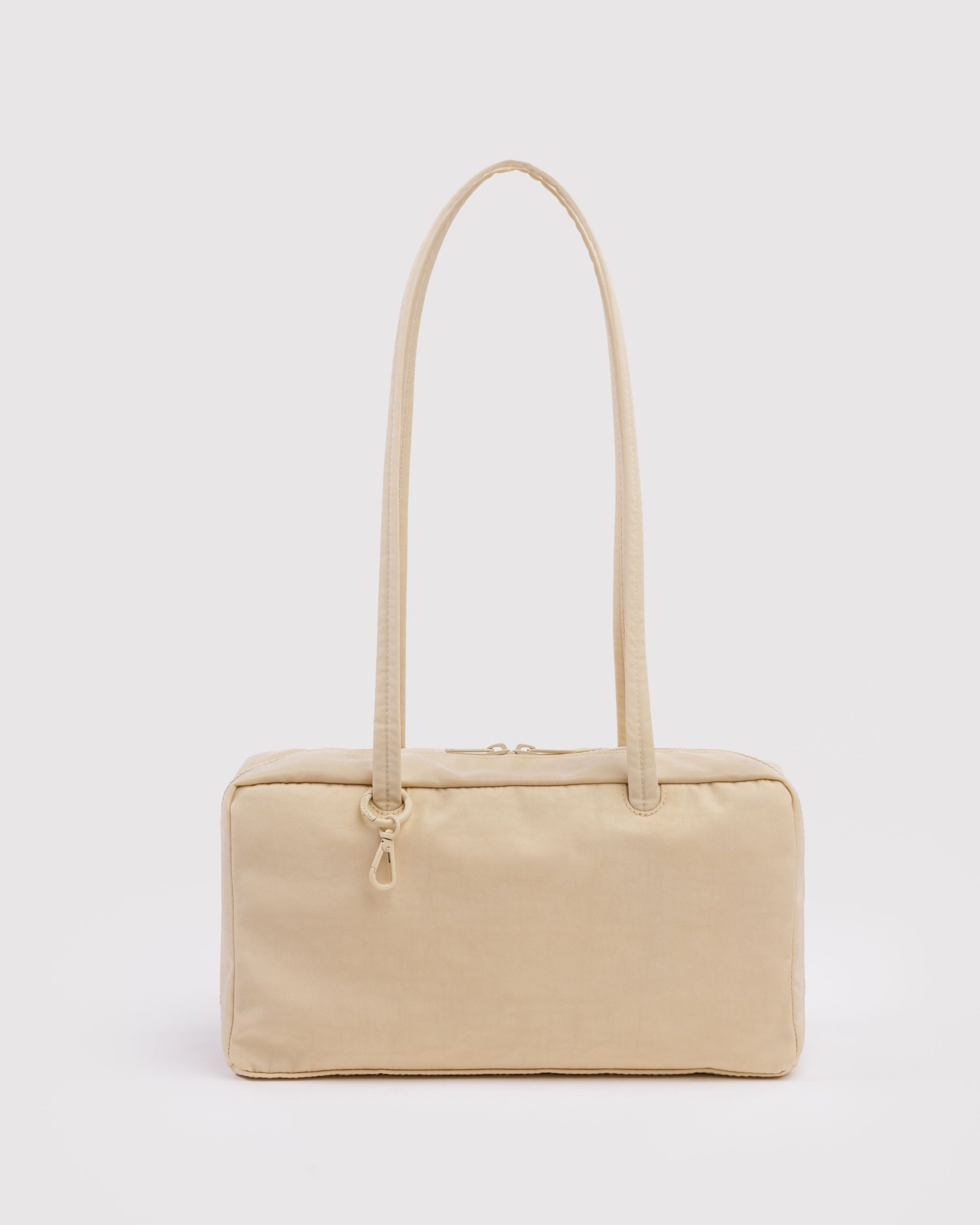 Light yellow handbag with double carry handles, top double zips and tonal ring with a clip.