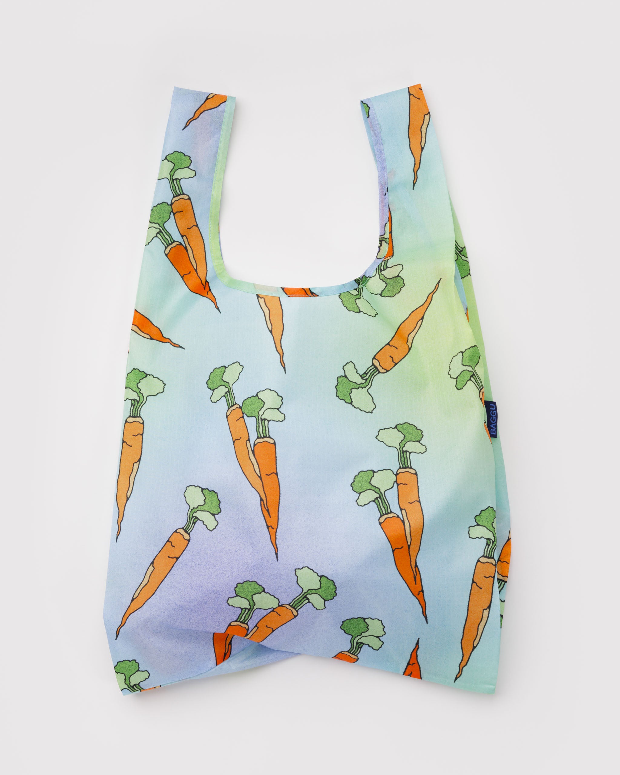 Reusable tote bag with carrot pattern on a light blue background.