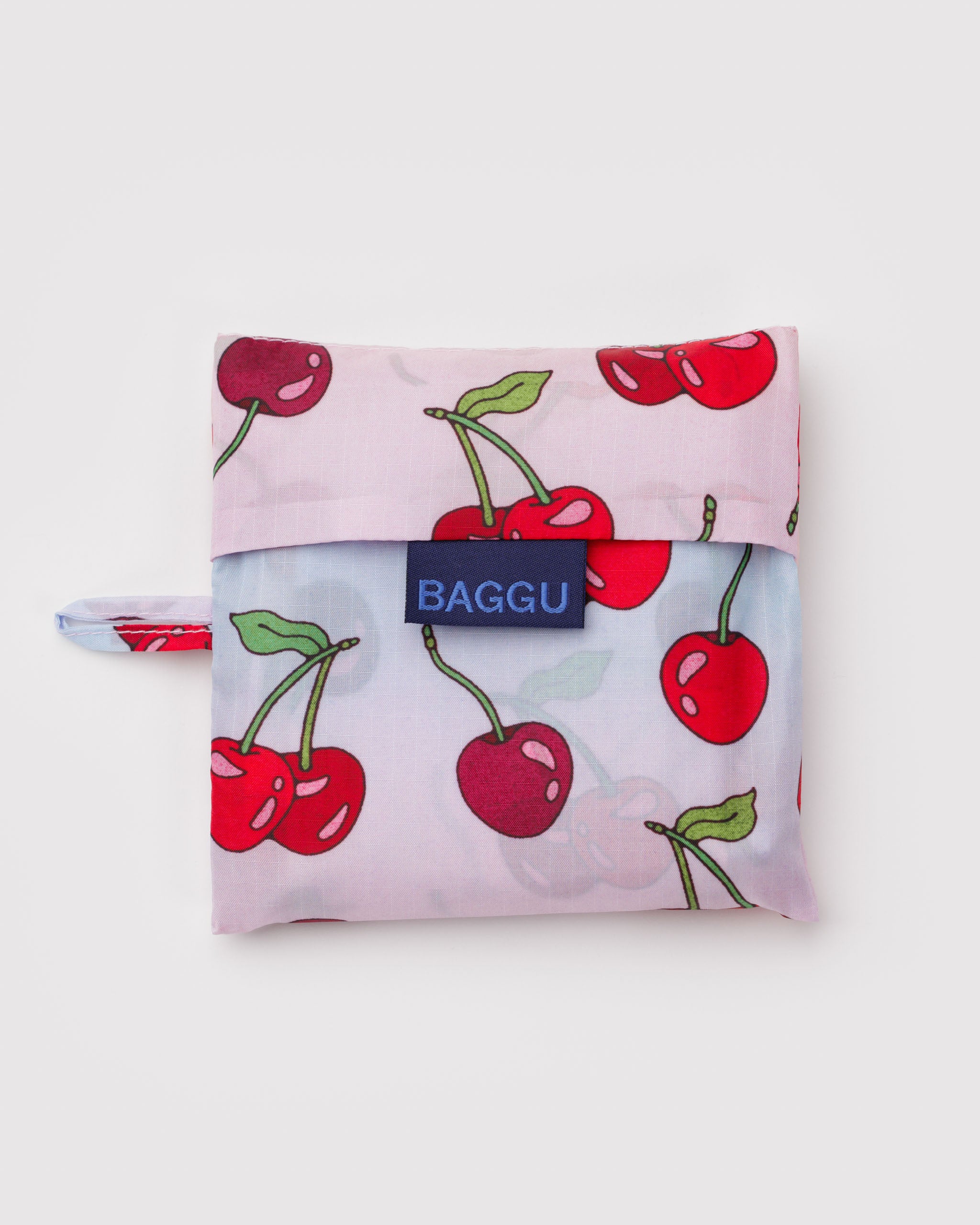 Standard Baggu shopping bag pouch with red cherry and green leaf design, 'BAGGU' branding and hanging loop.