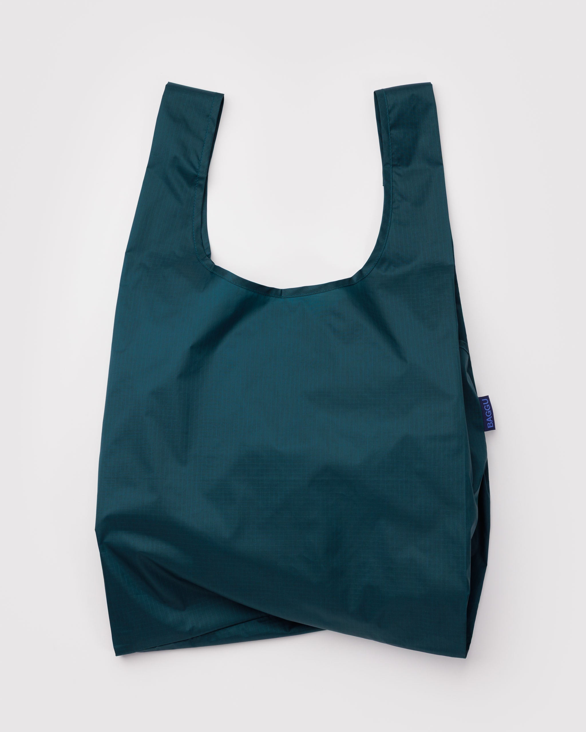 Teal reusable tote bag with handles and BAGGU tag.