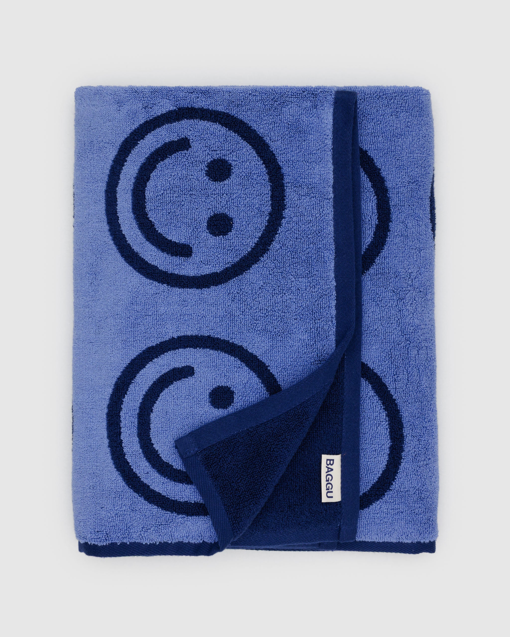 Blue towel with smiley face design and 'Baggu' brand logo.