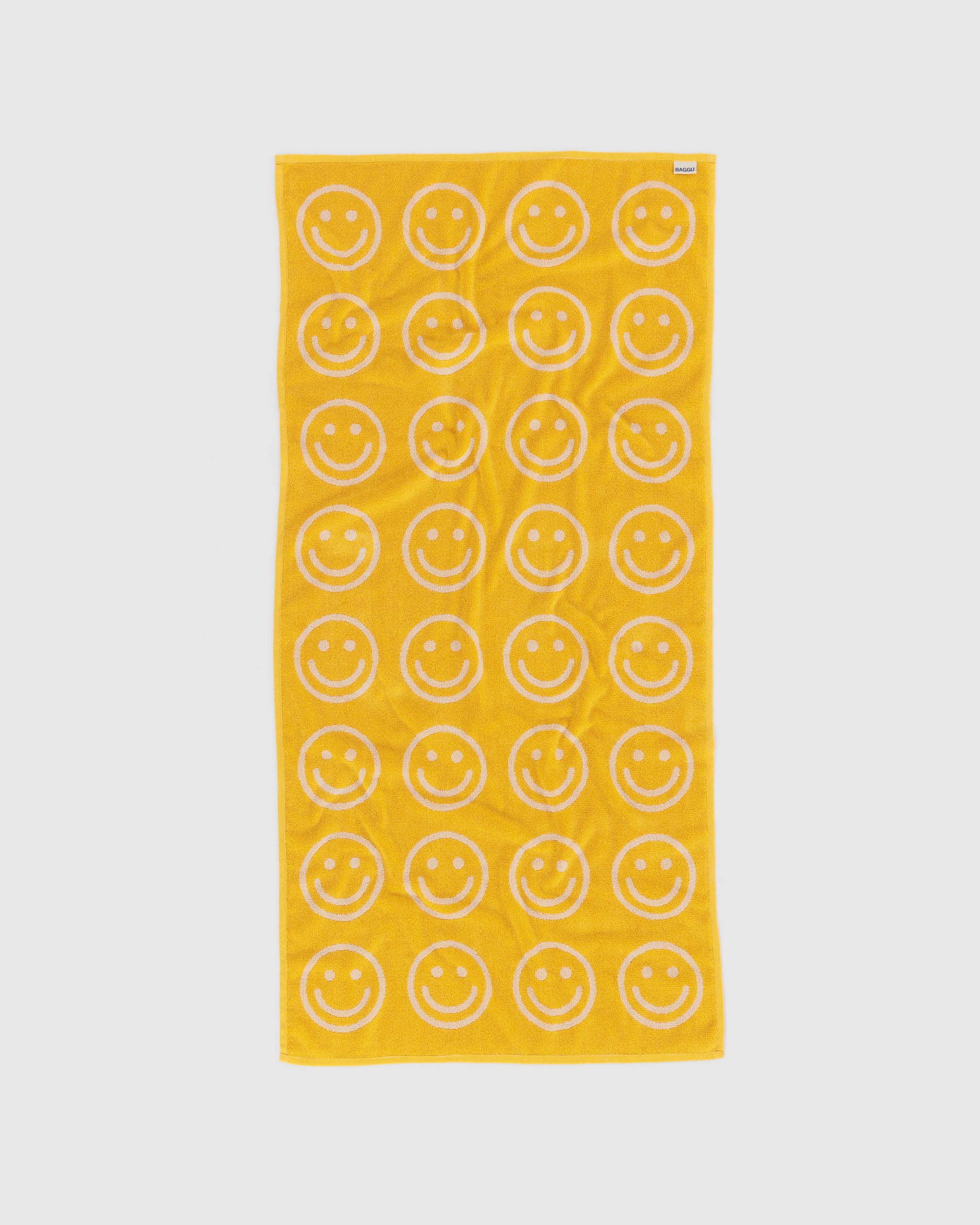 Yellow towel with white smiley face pattern.