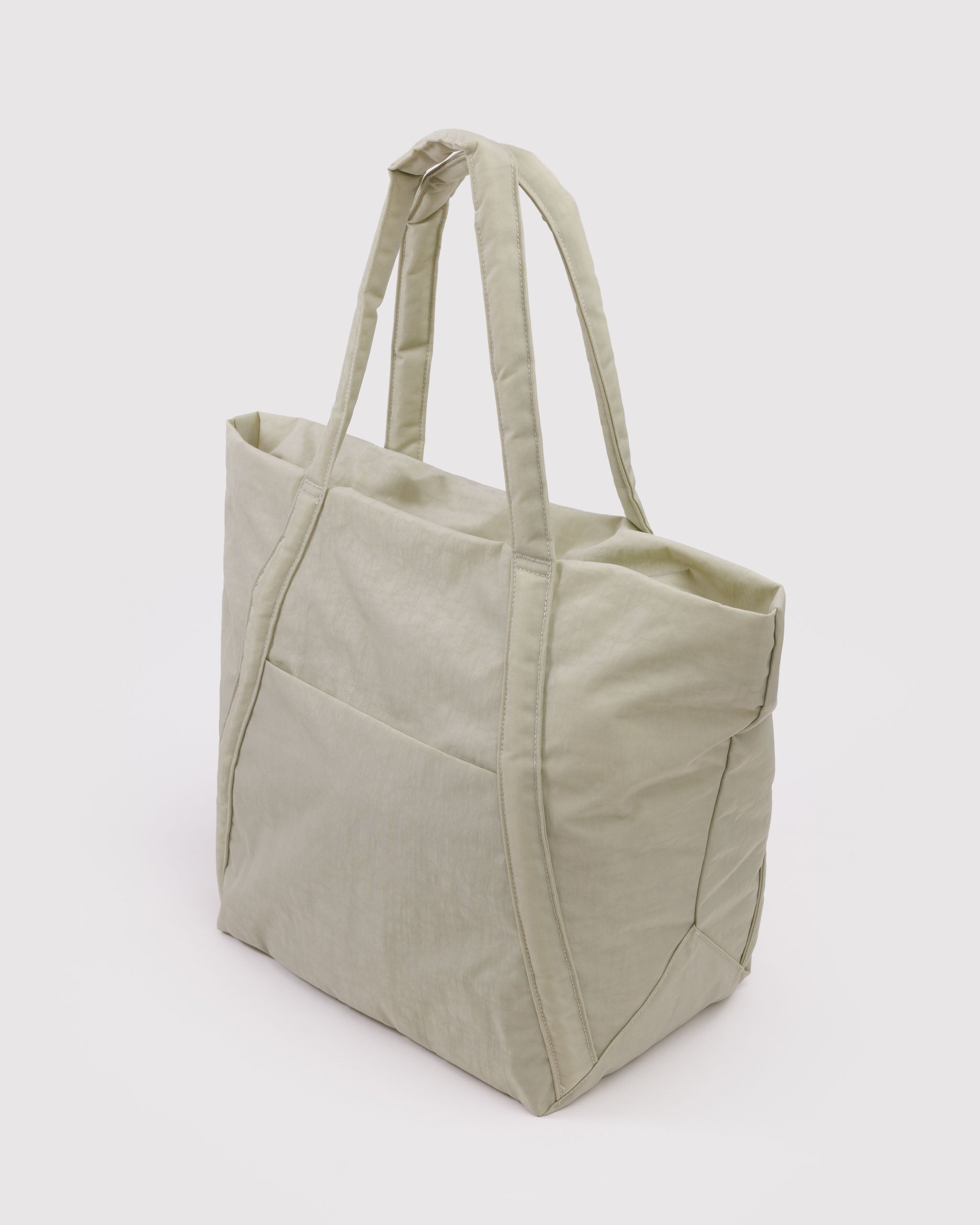 Side view of a light green hobo tote bag in trapezoid shape.