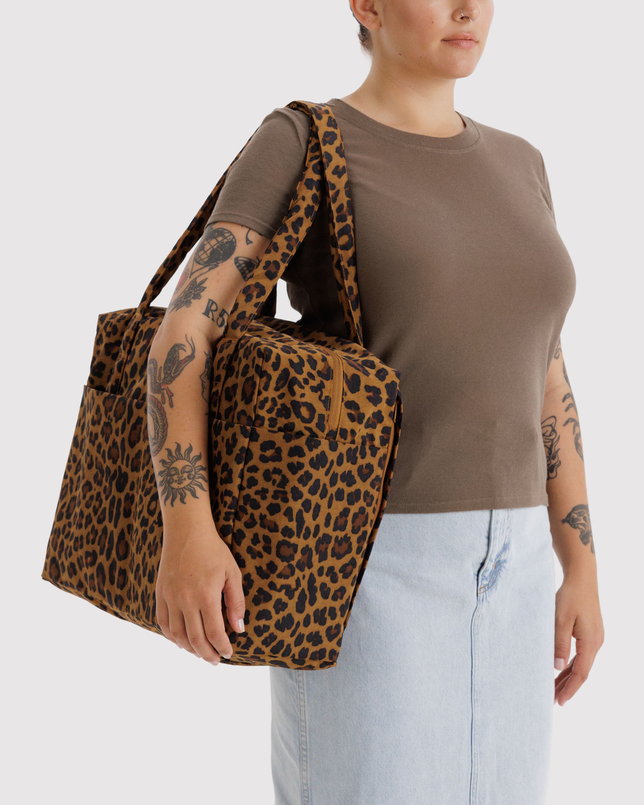 Woman carrying a leopard print bag on shoulder.