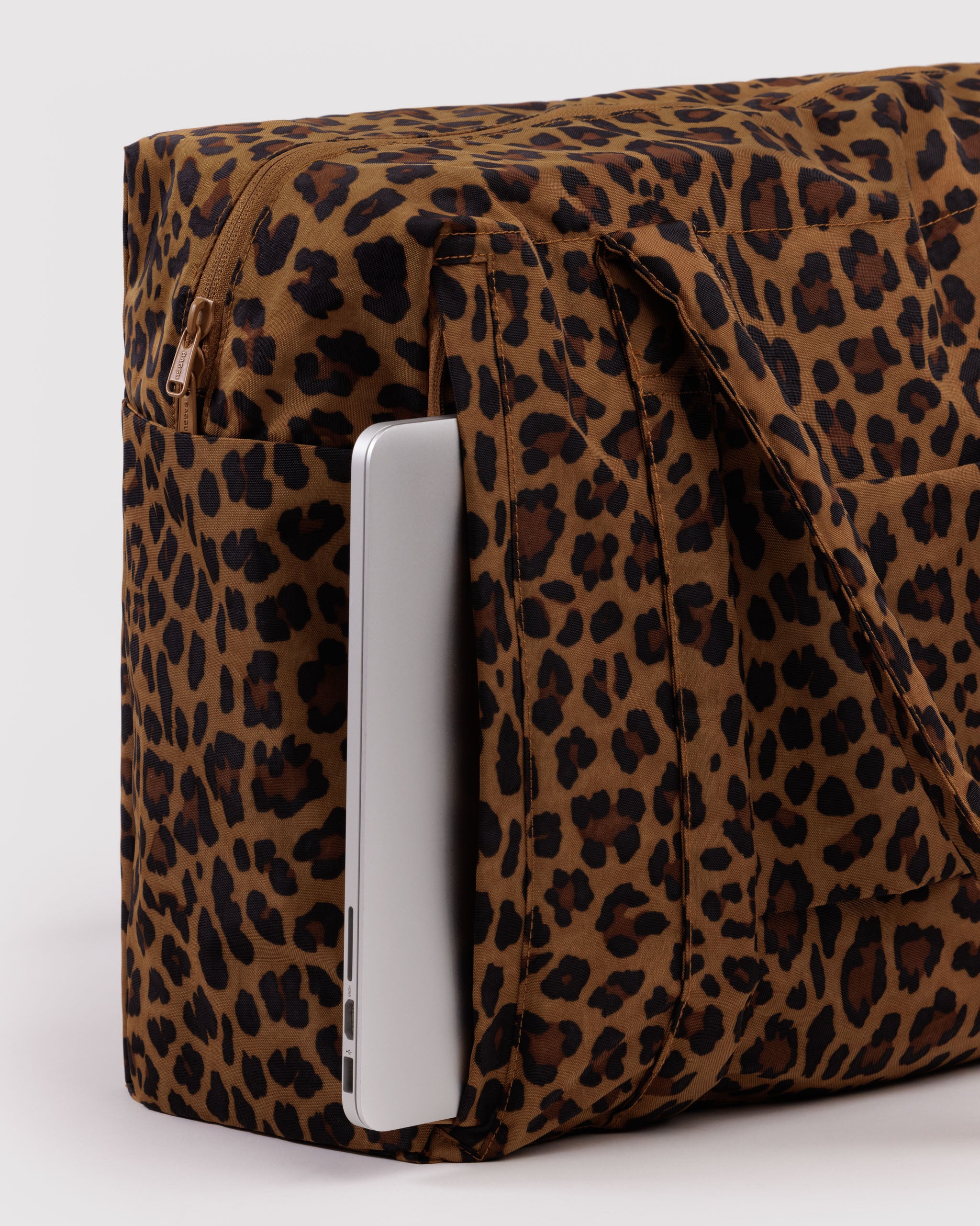Leopard print bag with a computer inside outside zip pocket.