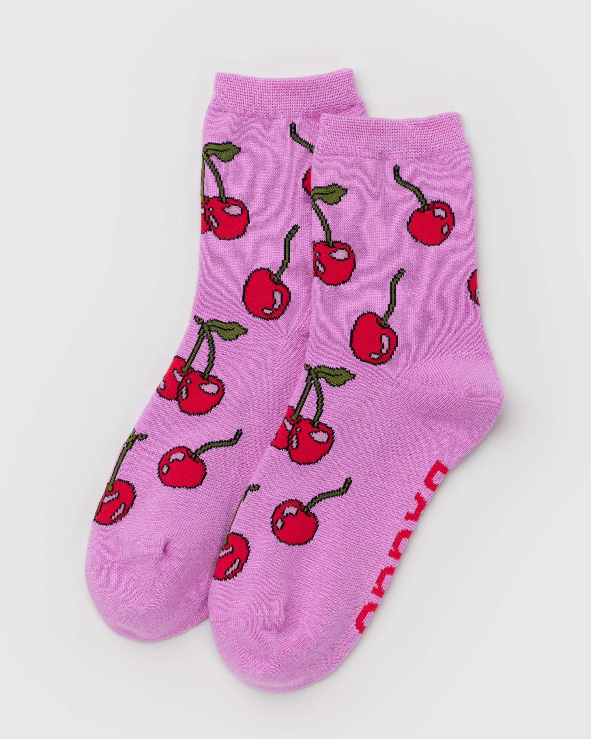 Pair of pink socks with red cherry pattern.