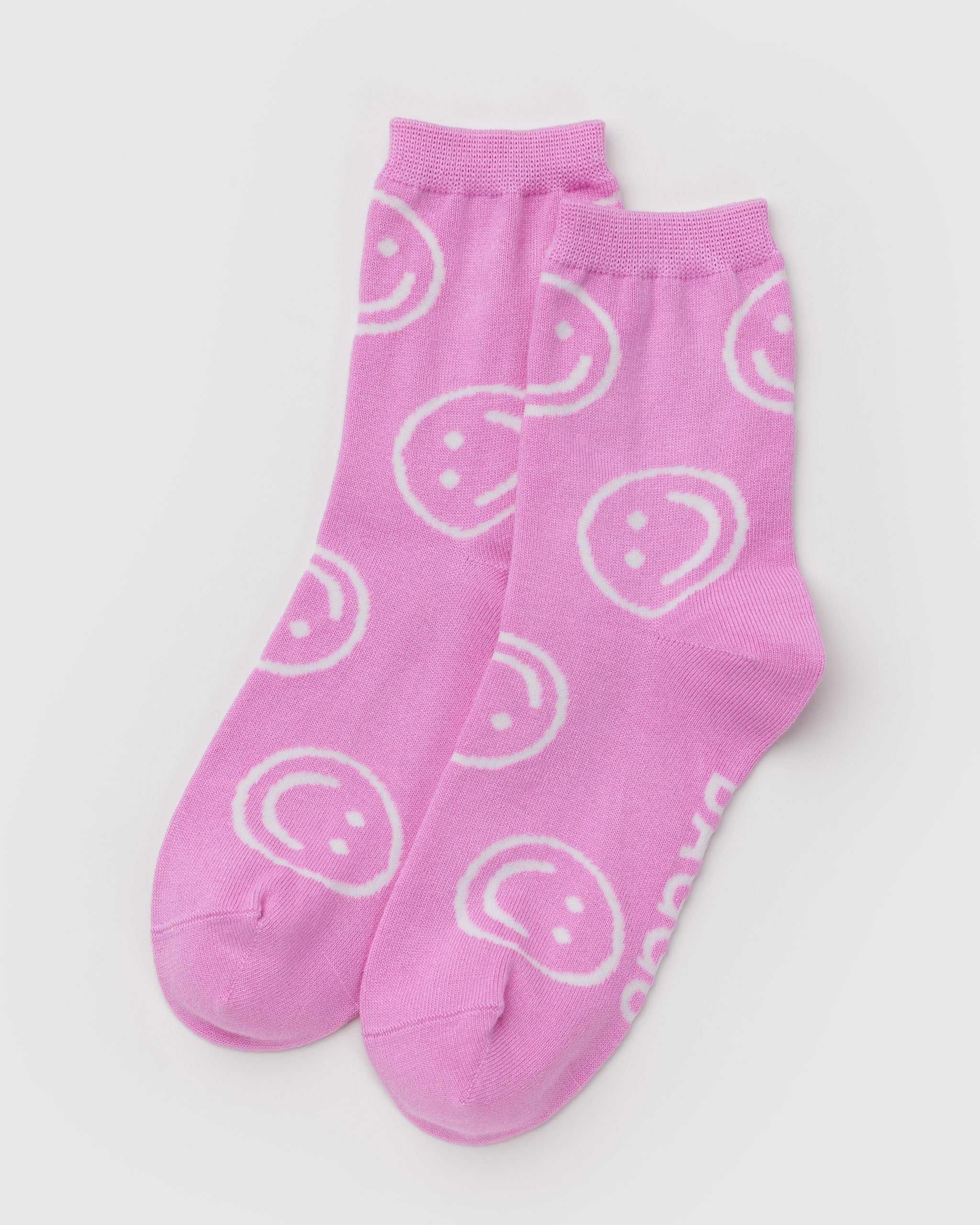 Pair of pink socks with smiley face patterns.