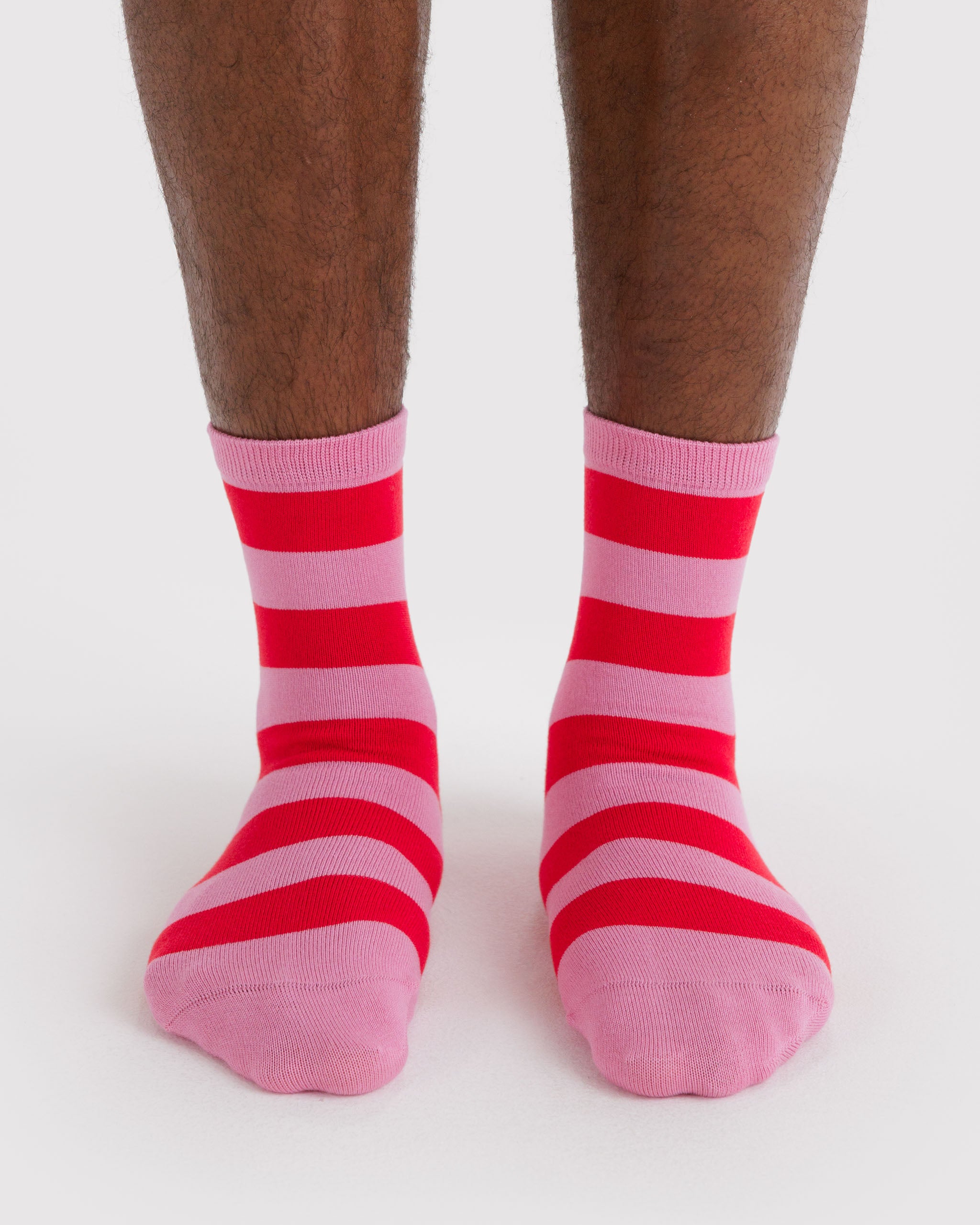 Red and pink striped socks worn by a person.