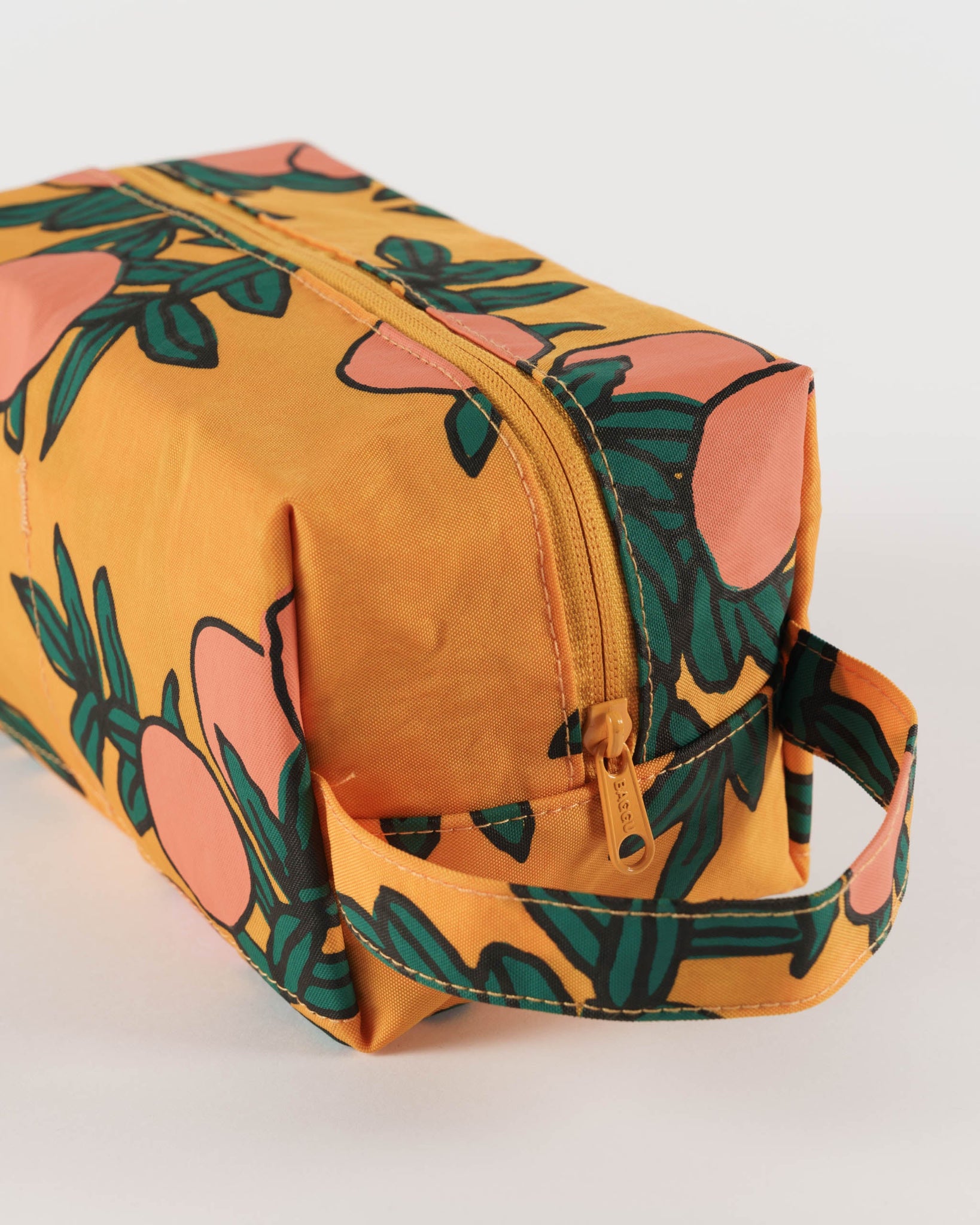 Yellow toiletry bag with oranges and green leaves pattern.