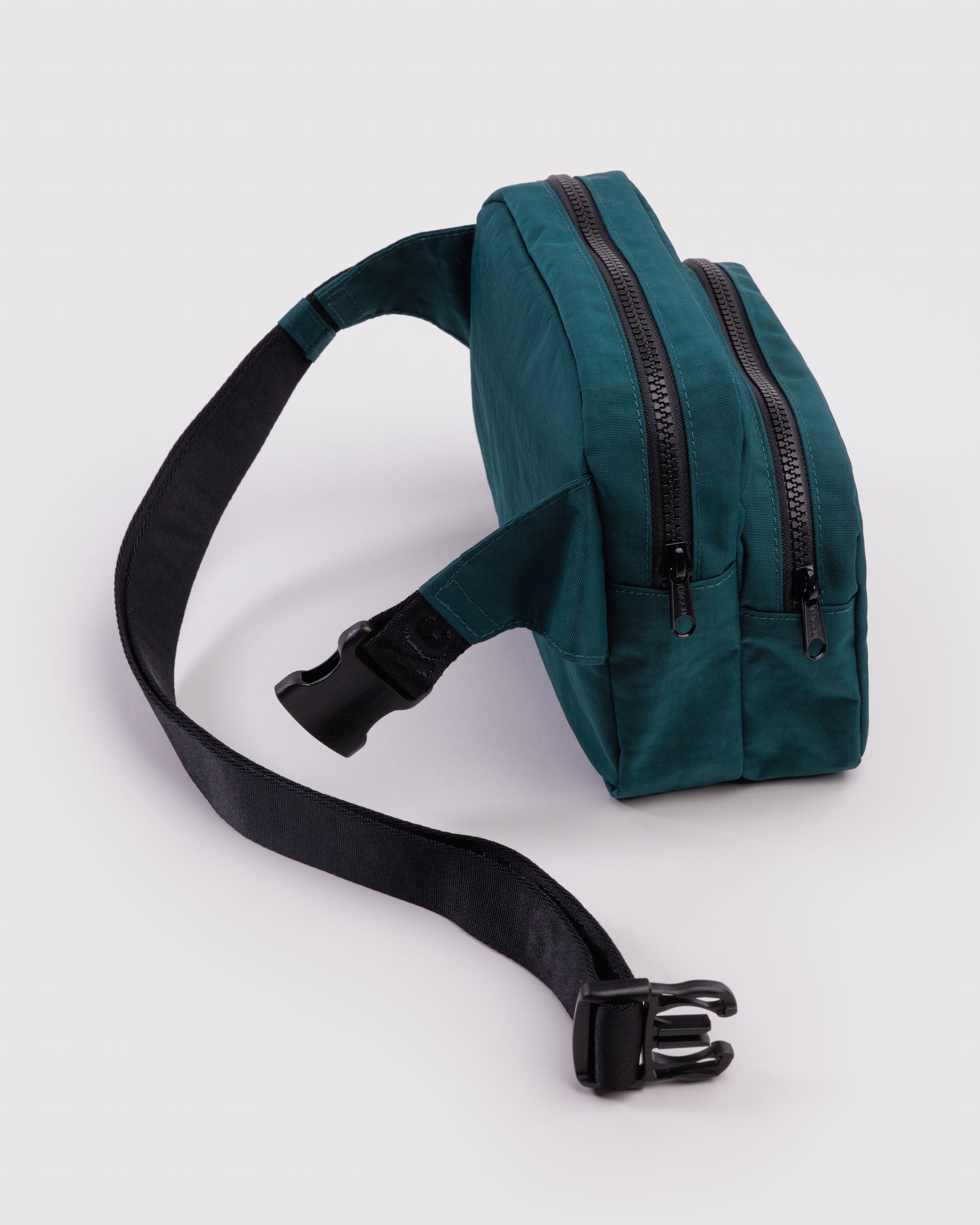 Teal waist bag with adjustable black strap clip open and black zips on two pouches.