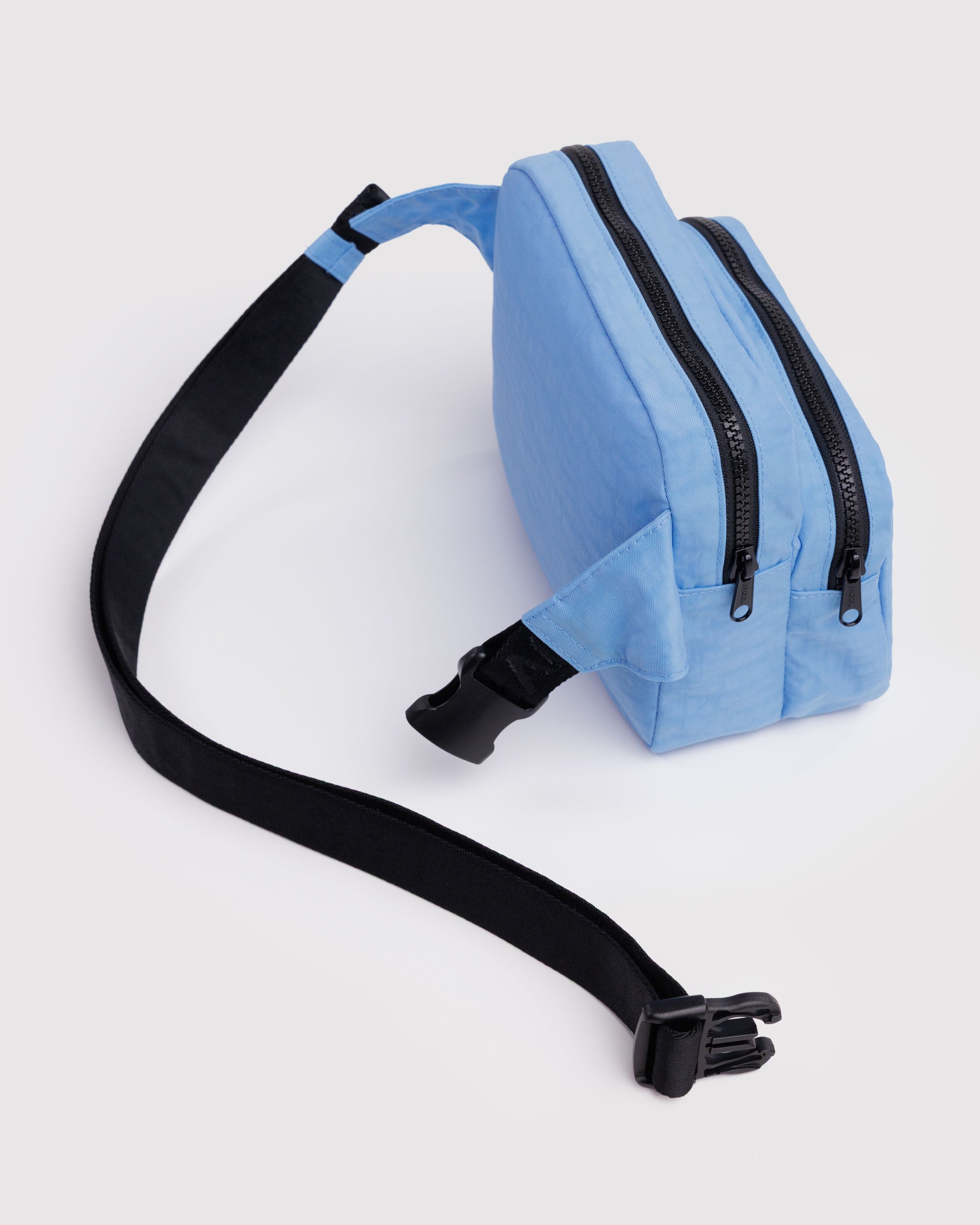 Light blue waist bag with an adjustable black strap with clip open and two pouches with zippers.