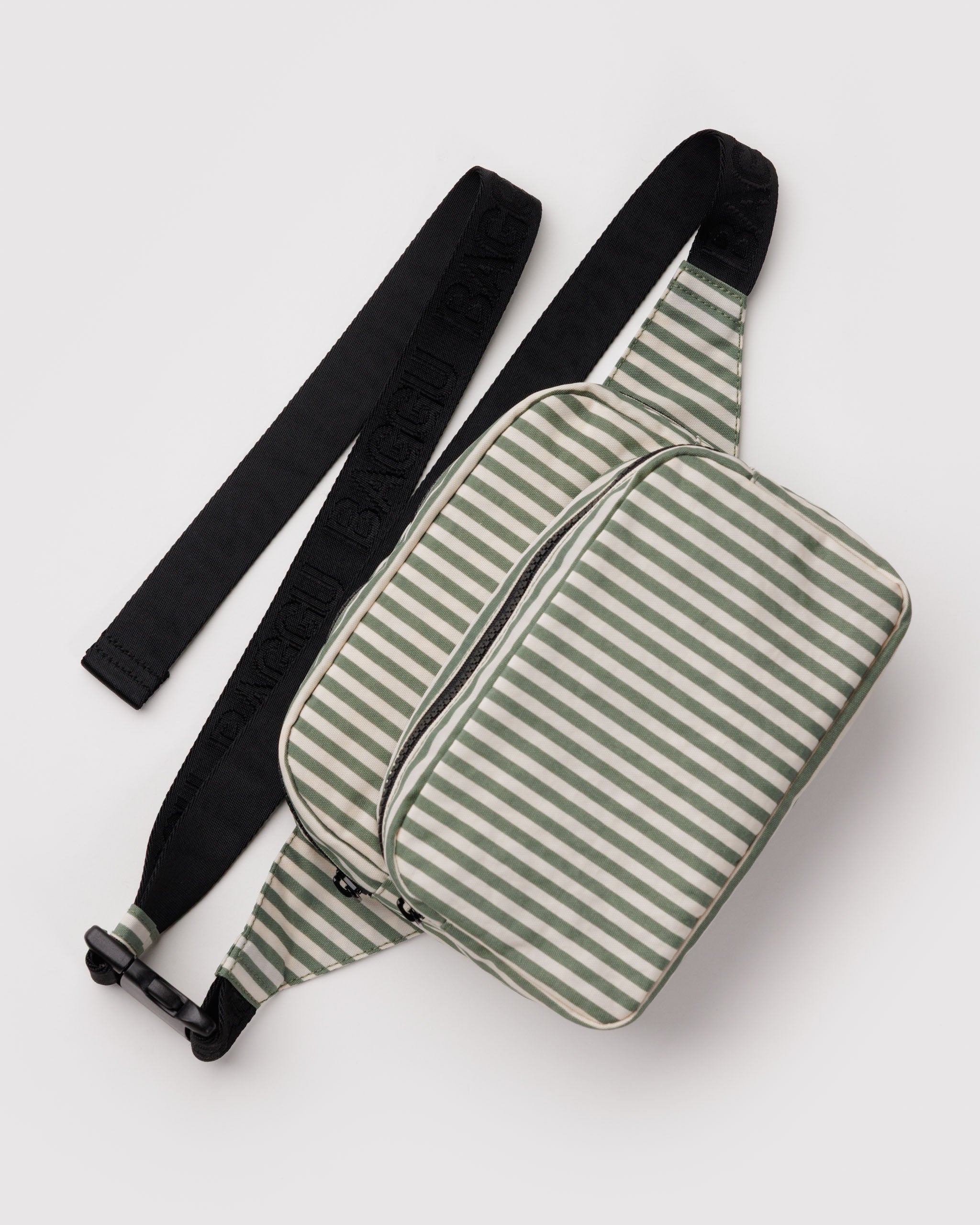 Green and white striped sling bag with two external zip pouches and an adjustable black webbed strap.