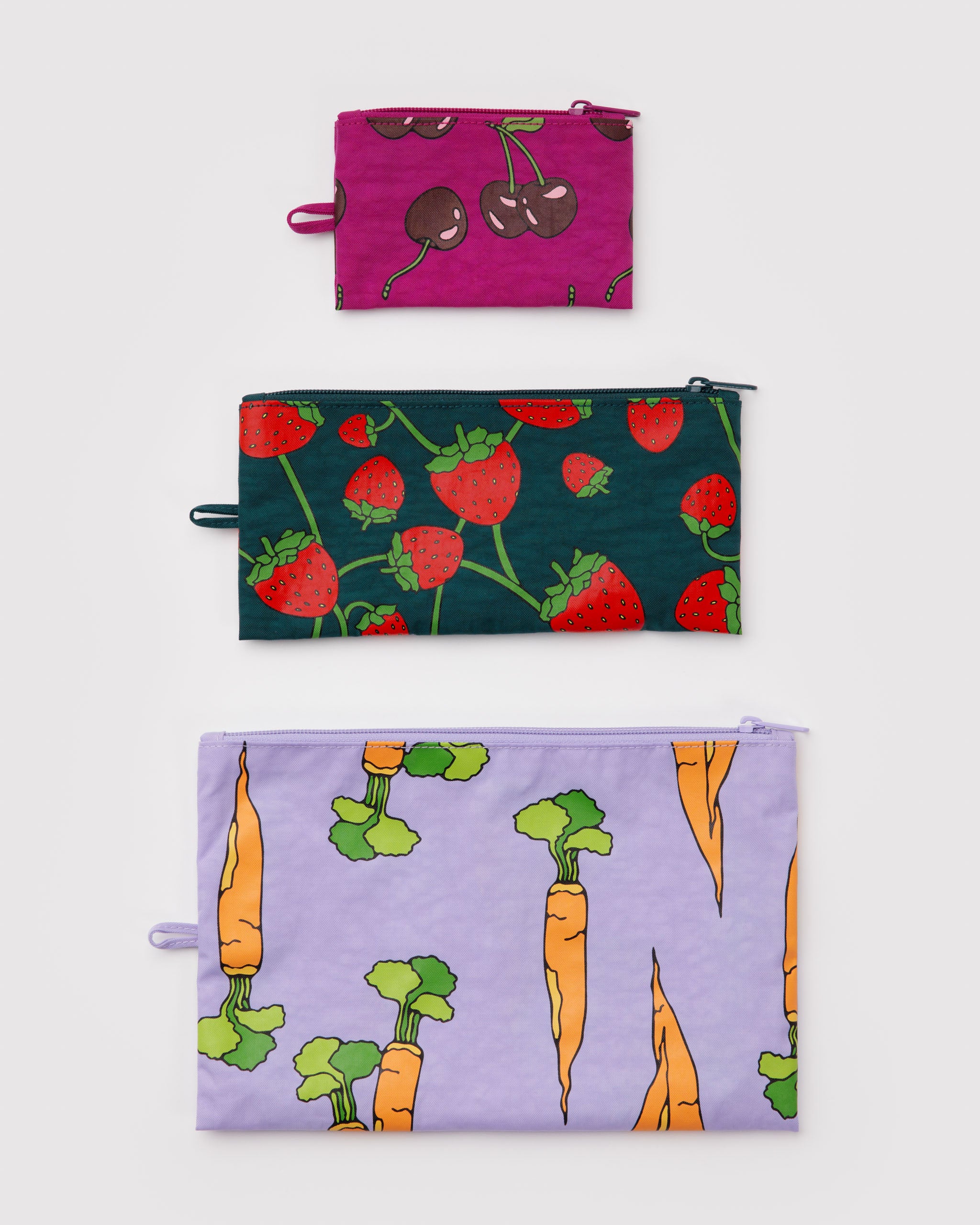 Three flat zip top pouches in different colours with cherries, strawberries and carrot patterns and a hanging loop at the side.