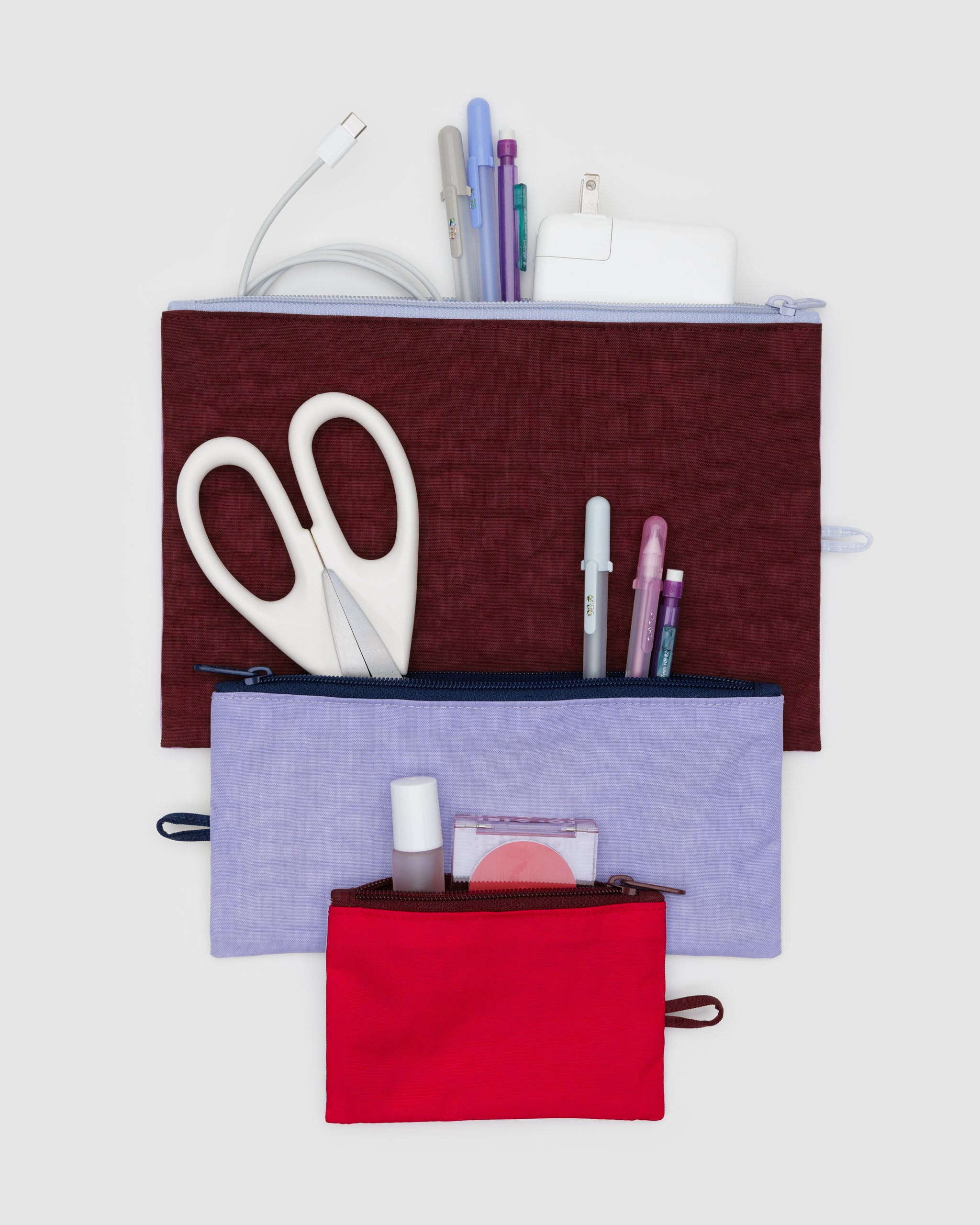 Three flat zip top pouches with items organised inside.
