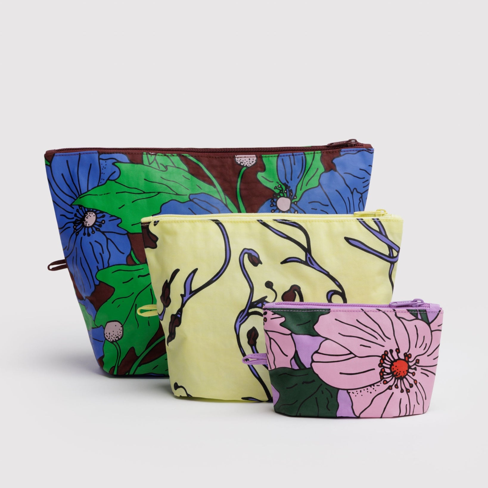 Three different sized floral-patterned zip pouches with hanging loop at side.