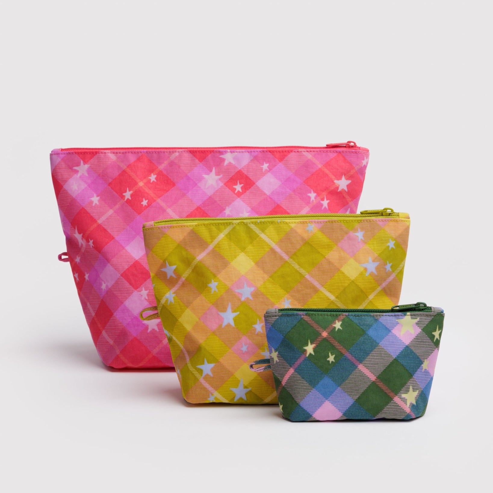 Three colorful plaid zip pouches standing on flat bottom ith hanging loop at side.