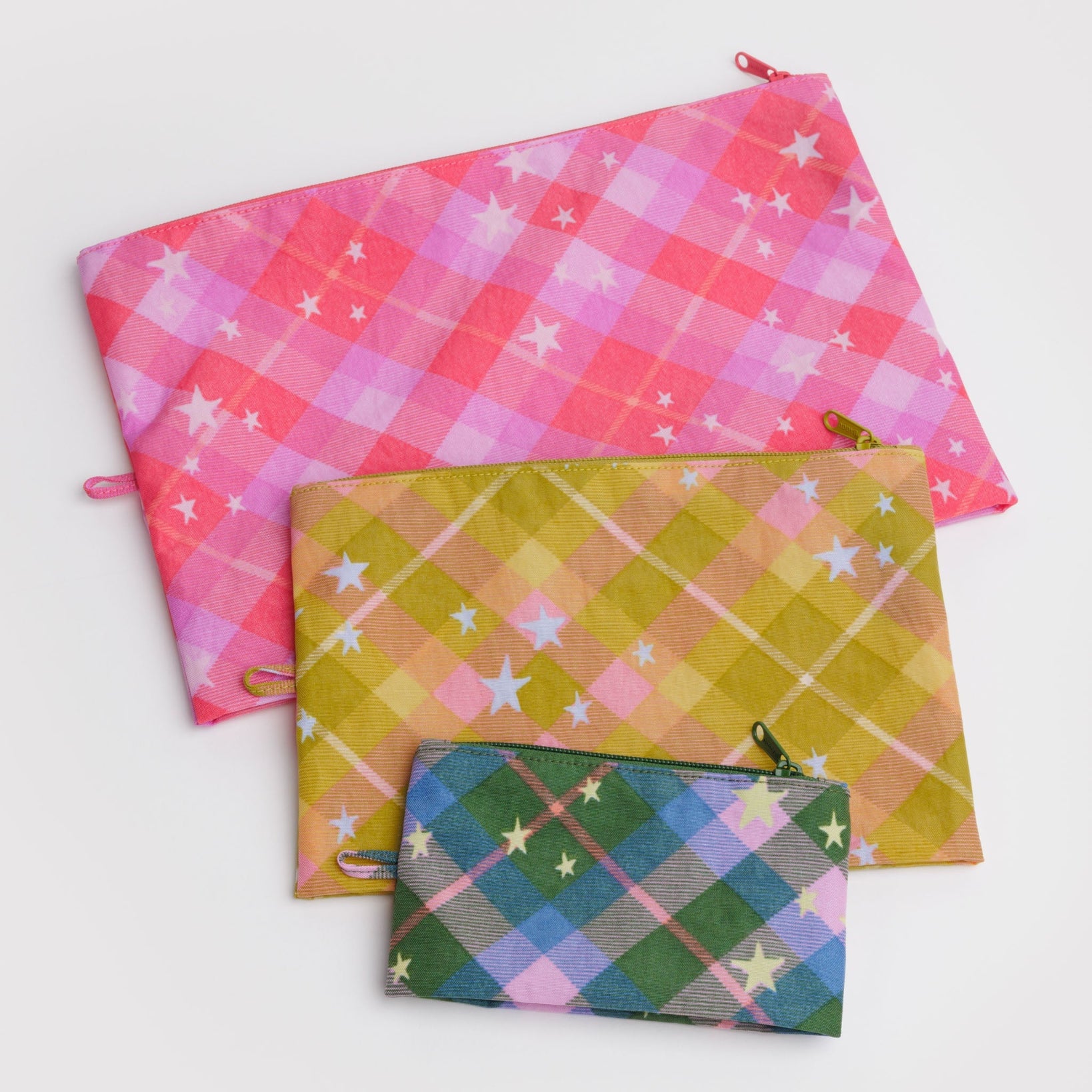 Three different sized colourful plaid pouches with star patterns, tonal zip closure and hanging loop.