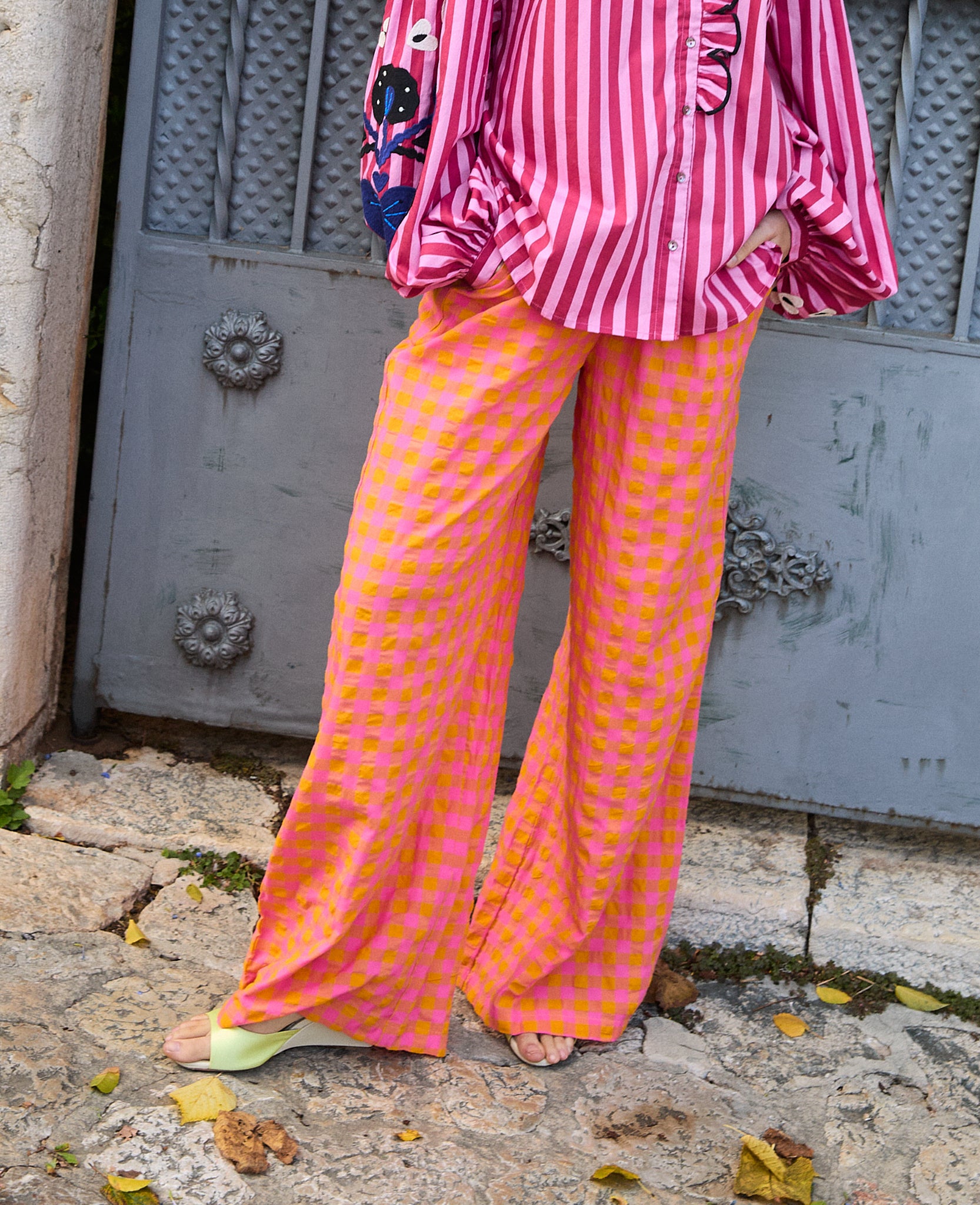 woman-standing-wearing-hilde-pants-wide-leg-style-with-pink-orange-checks-and-pink-stripe-shirt
