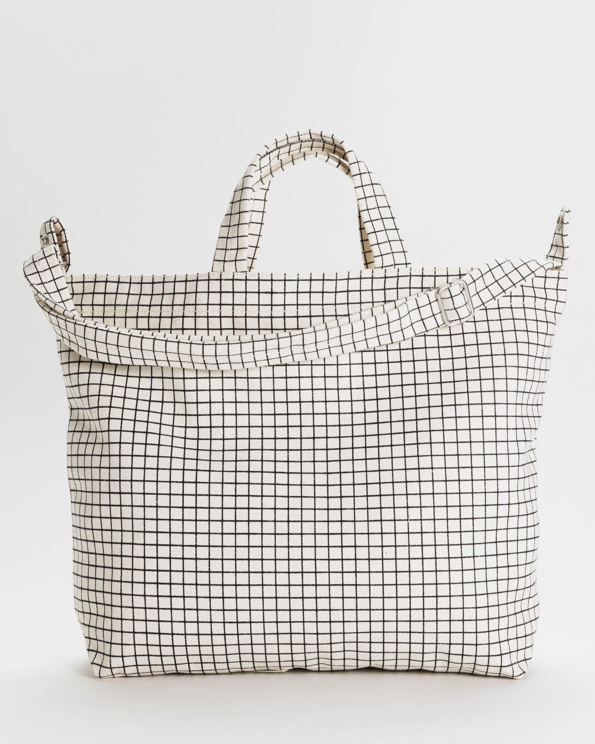 cotton-canvas-wide-tote-bag-in-black-and-white-grid-pattern-with-long-and-short-handles-and-zipper-top-flatlay