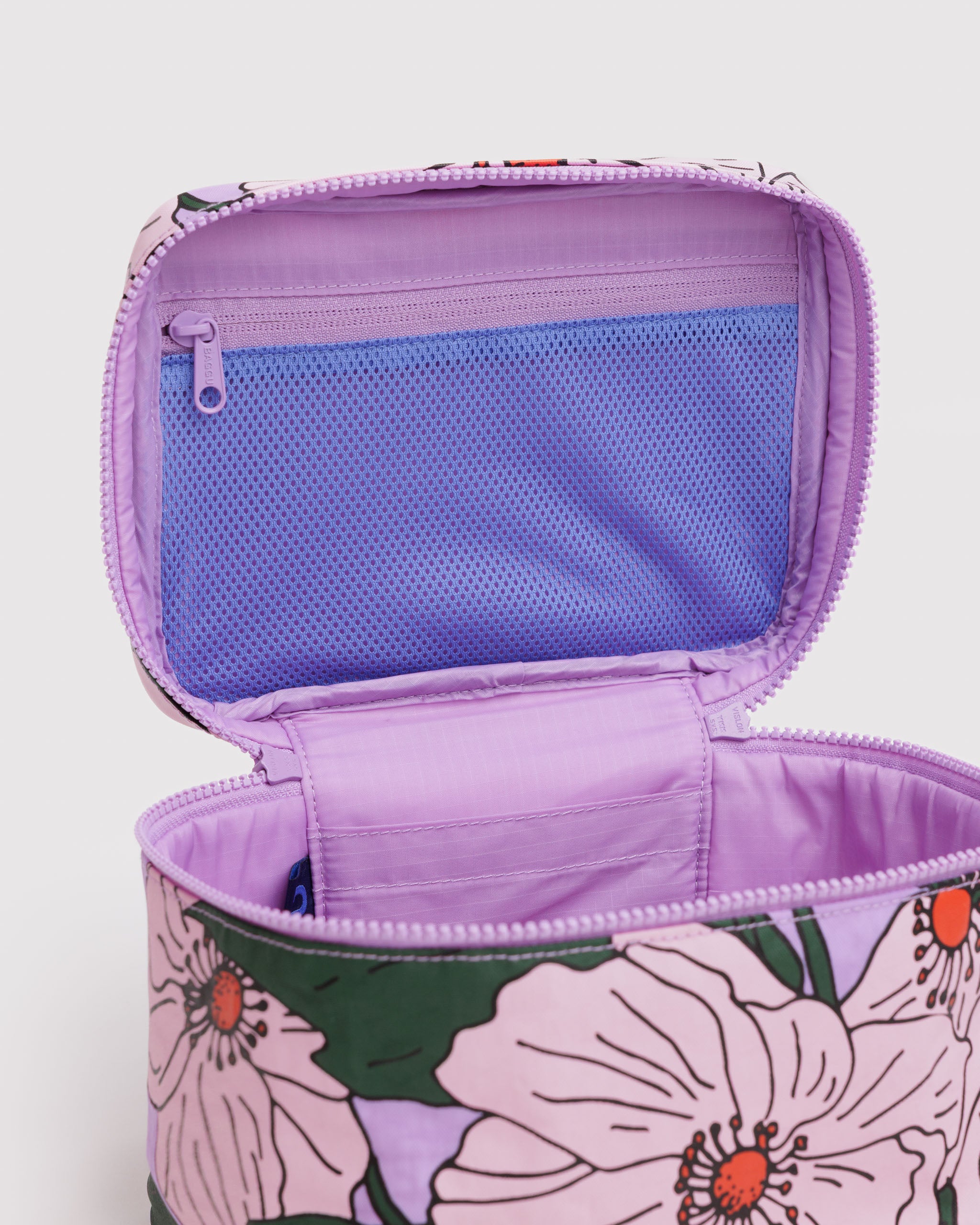 Floral pink poppy patterned makeup bag with a purple lining interior and mesh zip pouch on the lid.