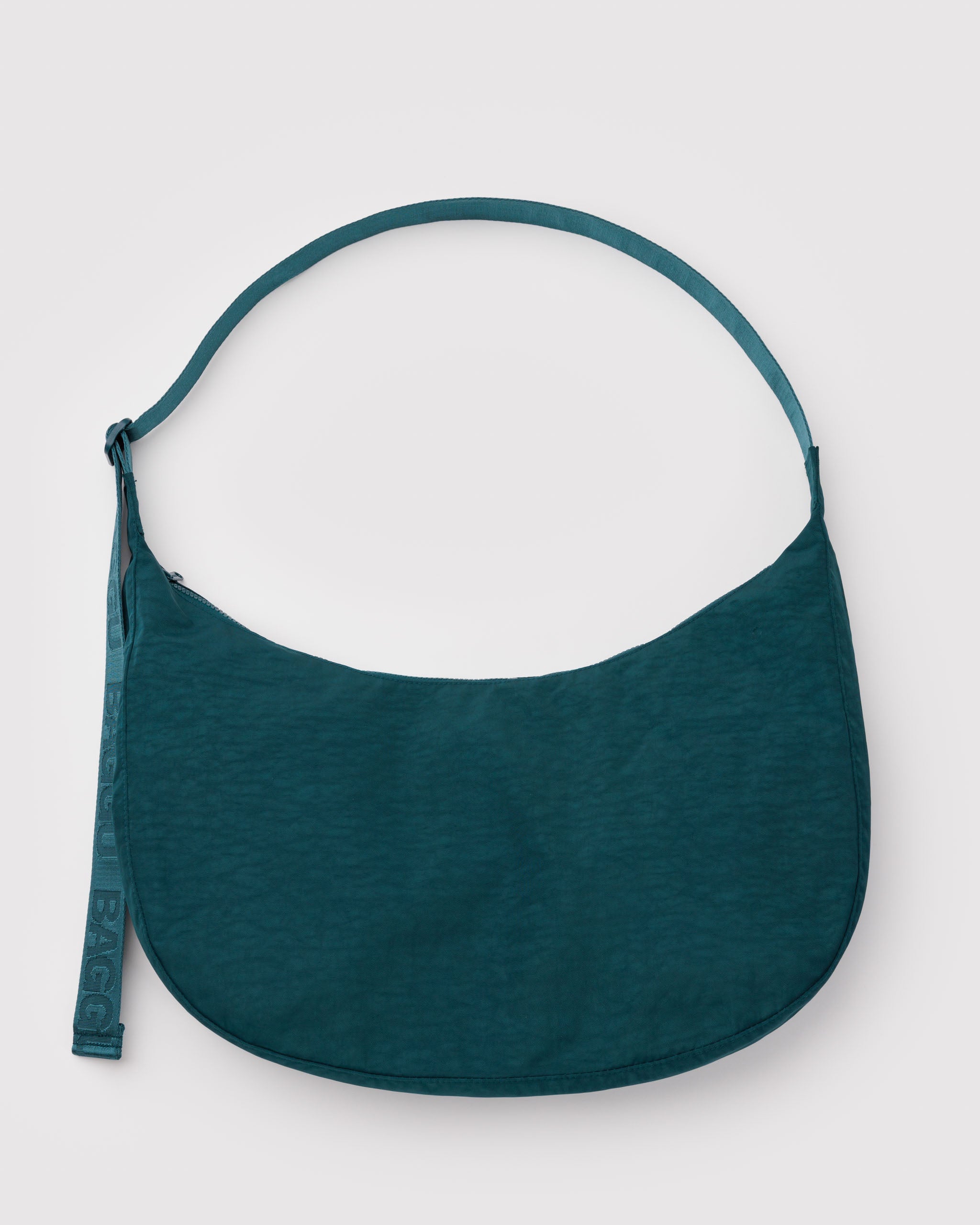 Large teal crescent shaped bag with adjustable wide strap and zip top.