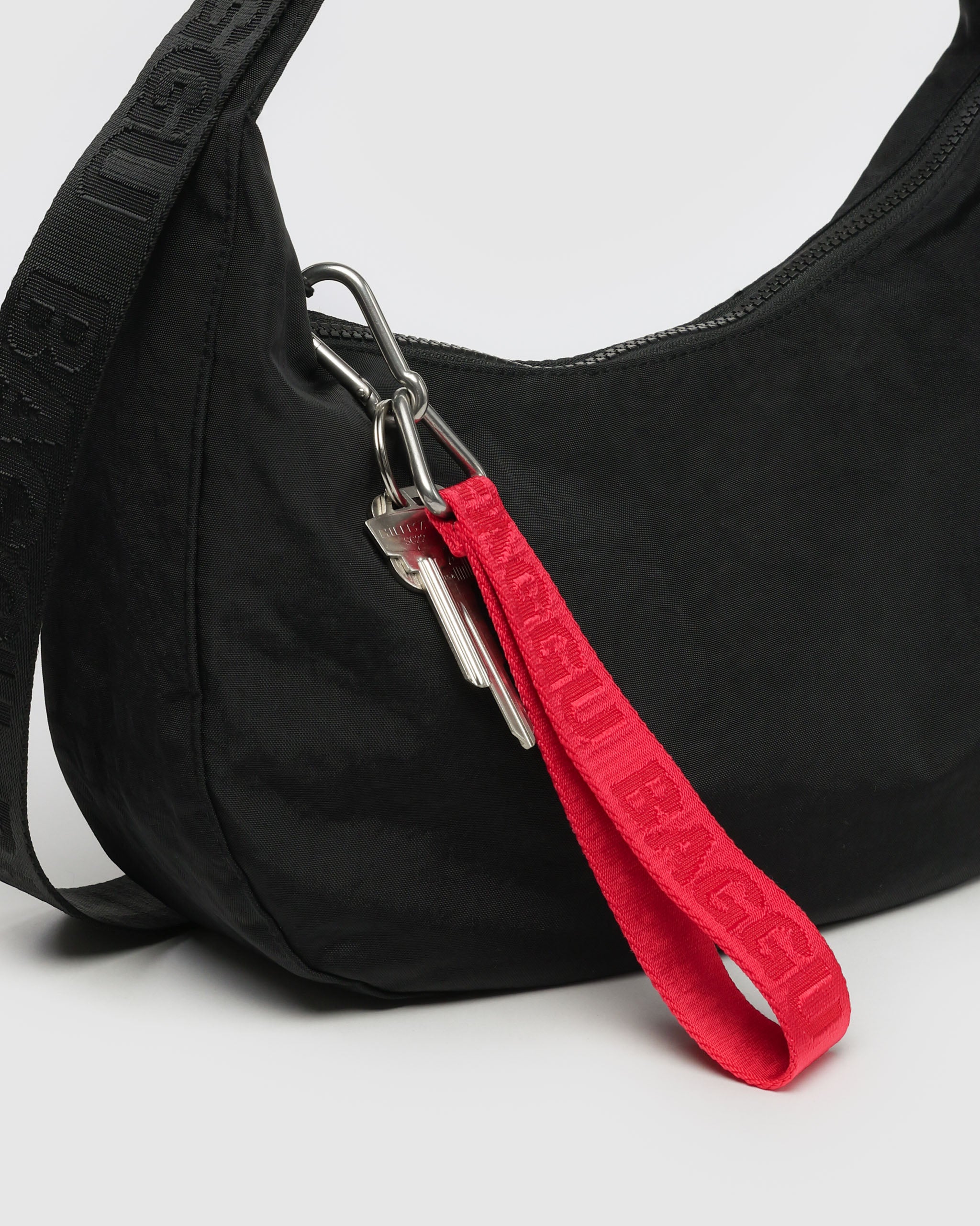 red-keychain-attached-to-black-handbag