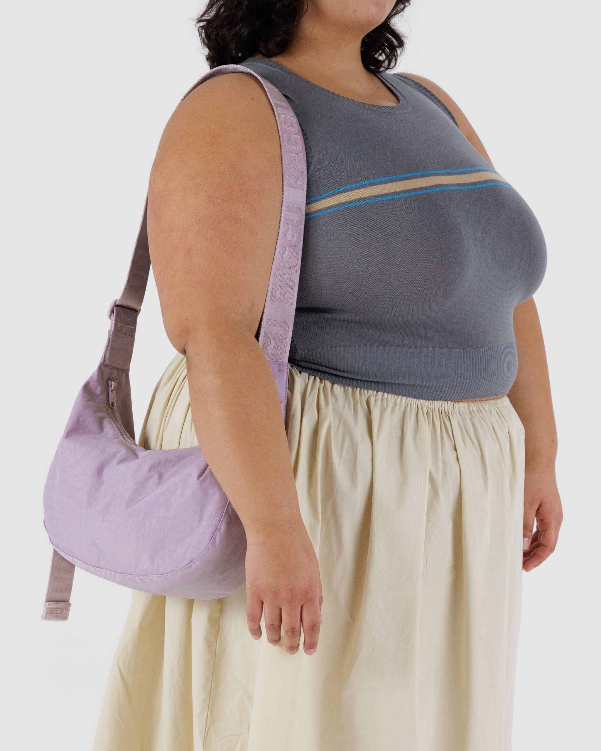 woman-wearing-dusty-pink-crescent-shaped-bag-with-strap-over-shoulder