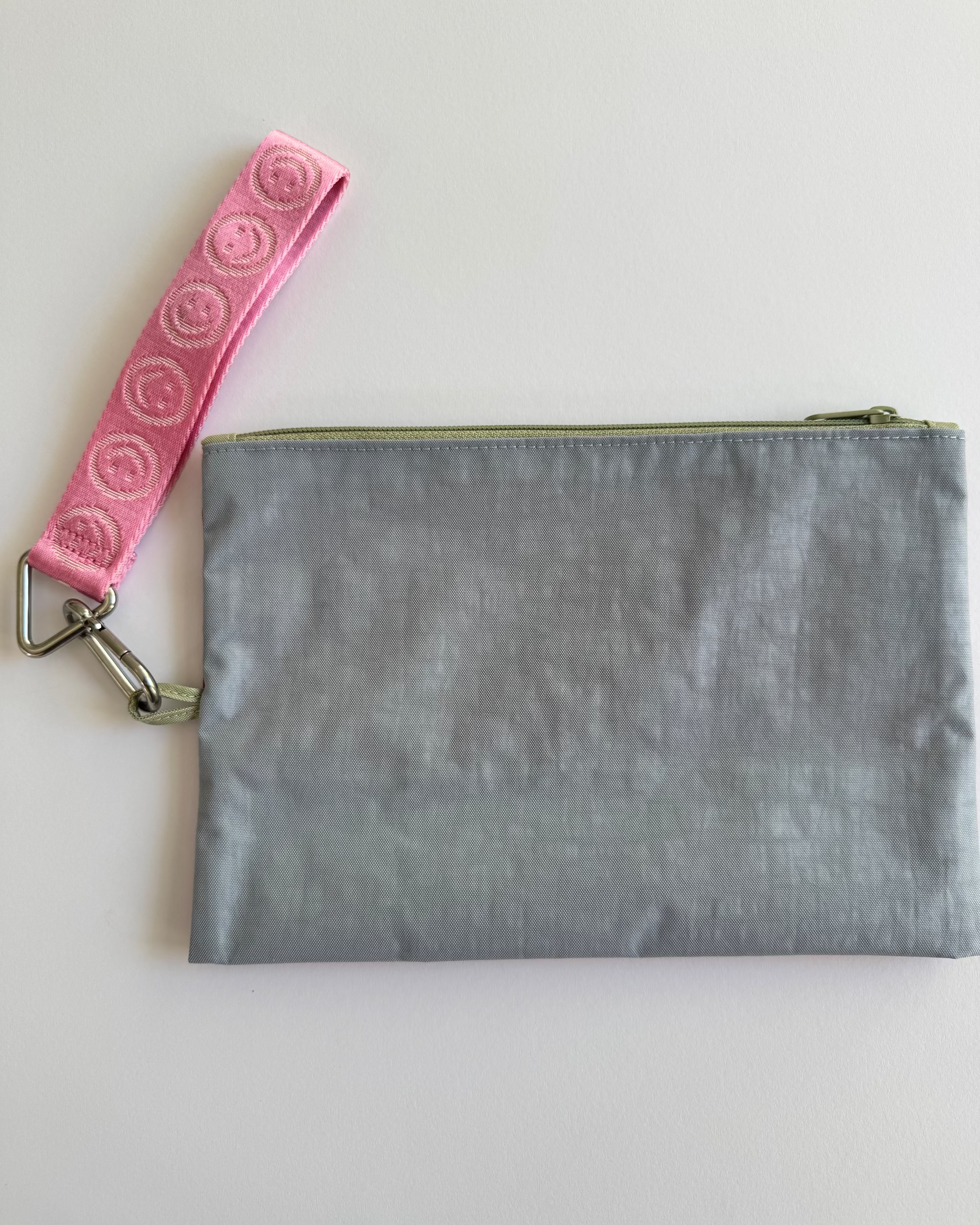Medium light blue side of go pouch with pink happy logo keychain attached.