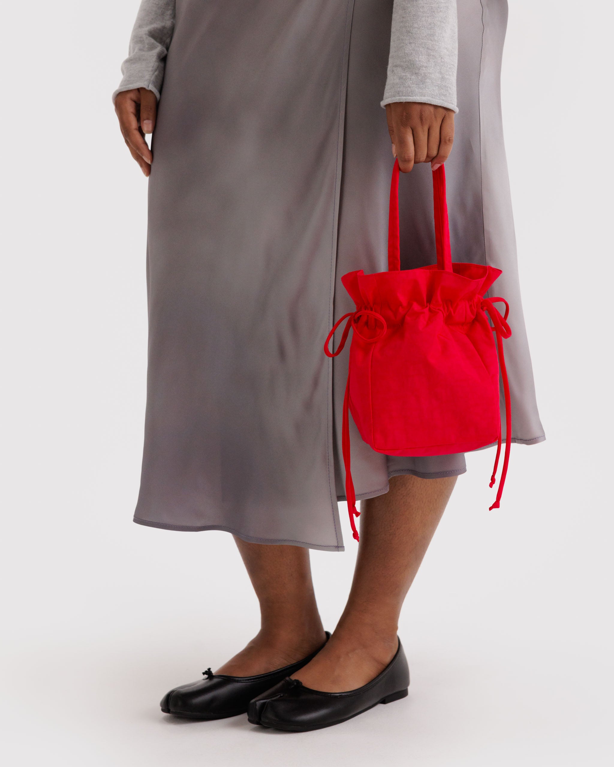 Person holding a red drawstring bag.