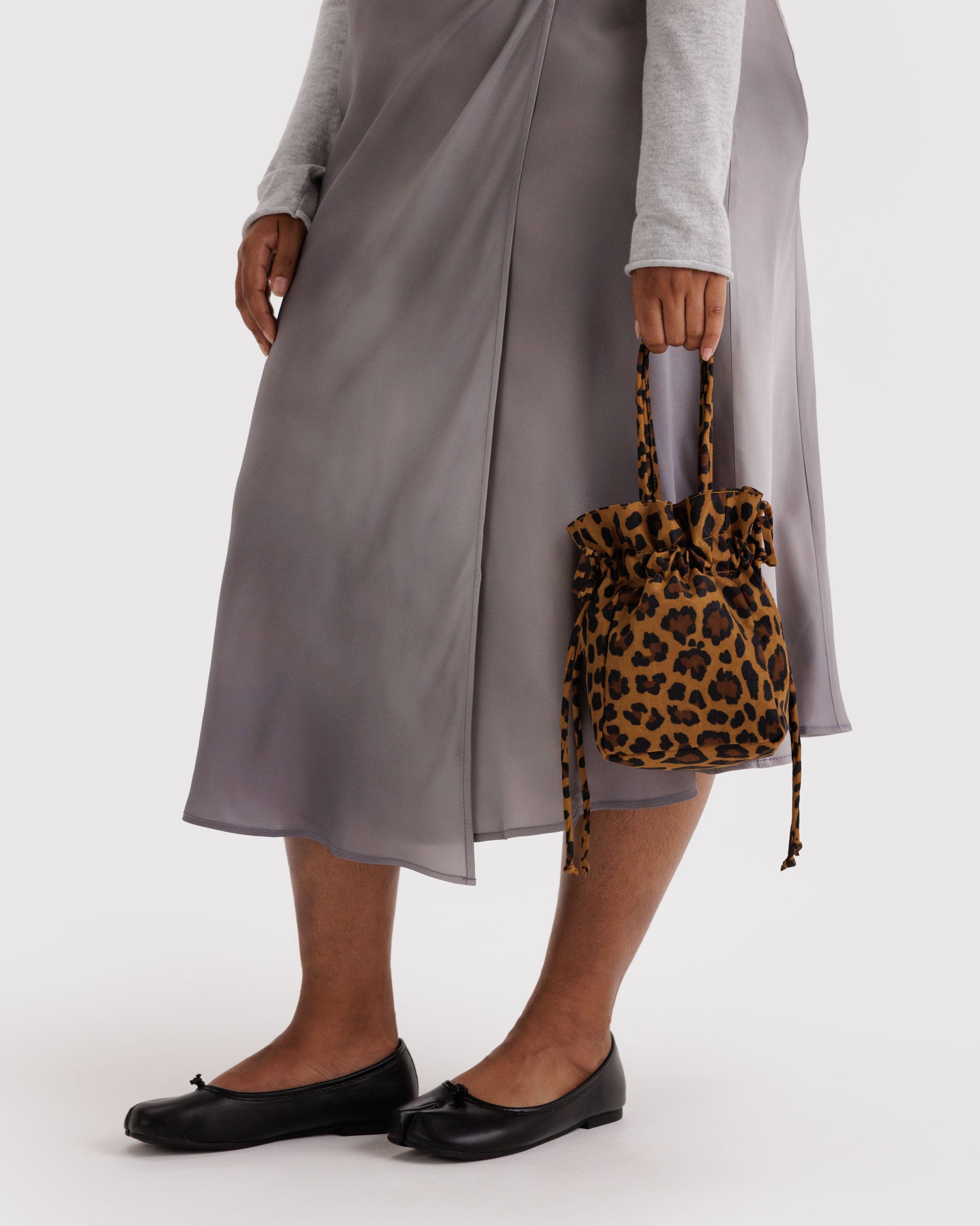 Person holding a leopard print drawstring bag